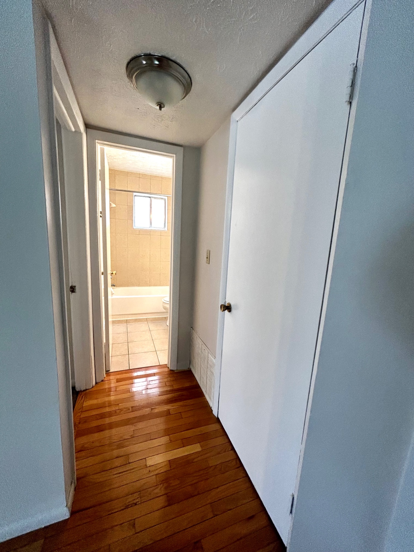 2150 N 4th St. Unit C hallway with hardwood floors leading to full bathroom