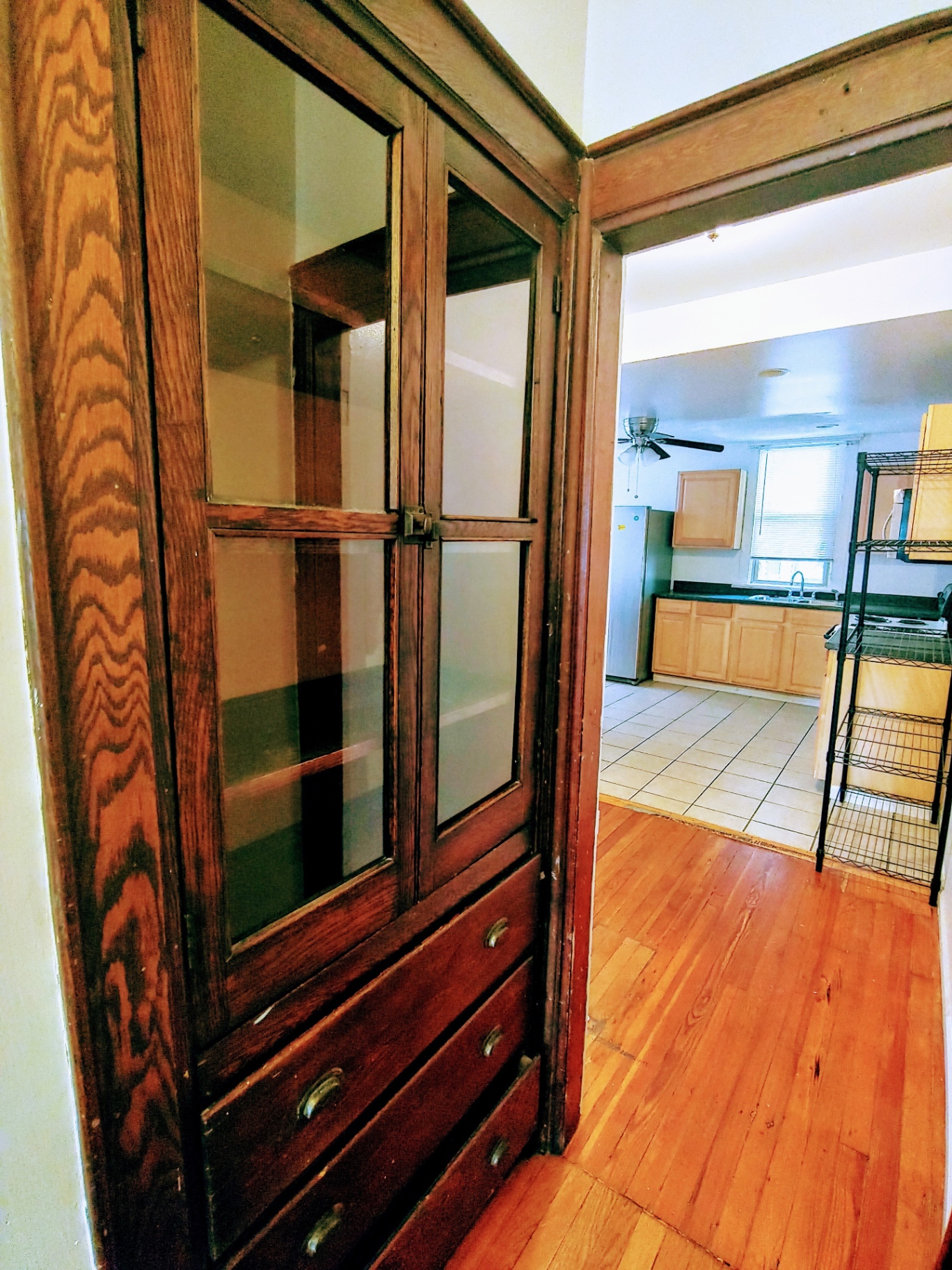 1818 Summit St. original built-in wood hutch with glass doors and drawers, view into kitchen