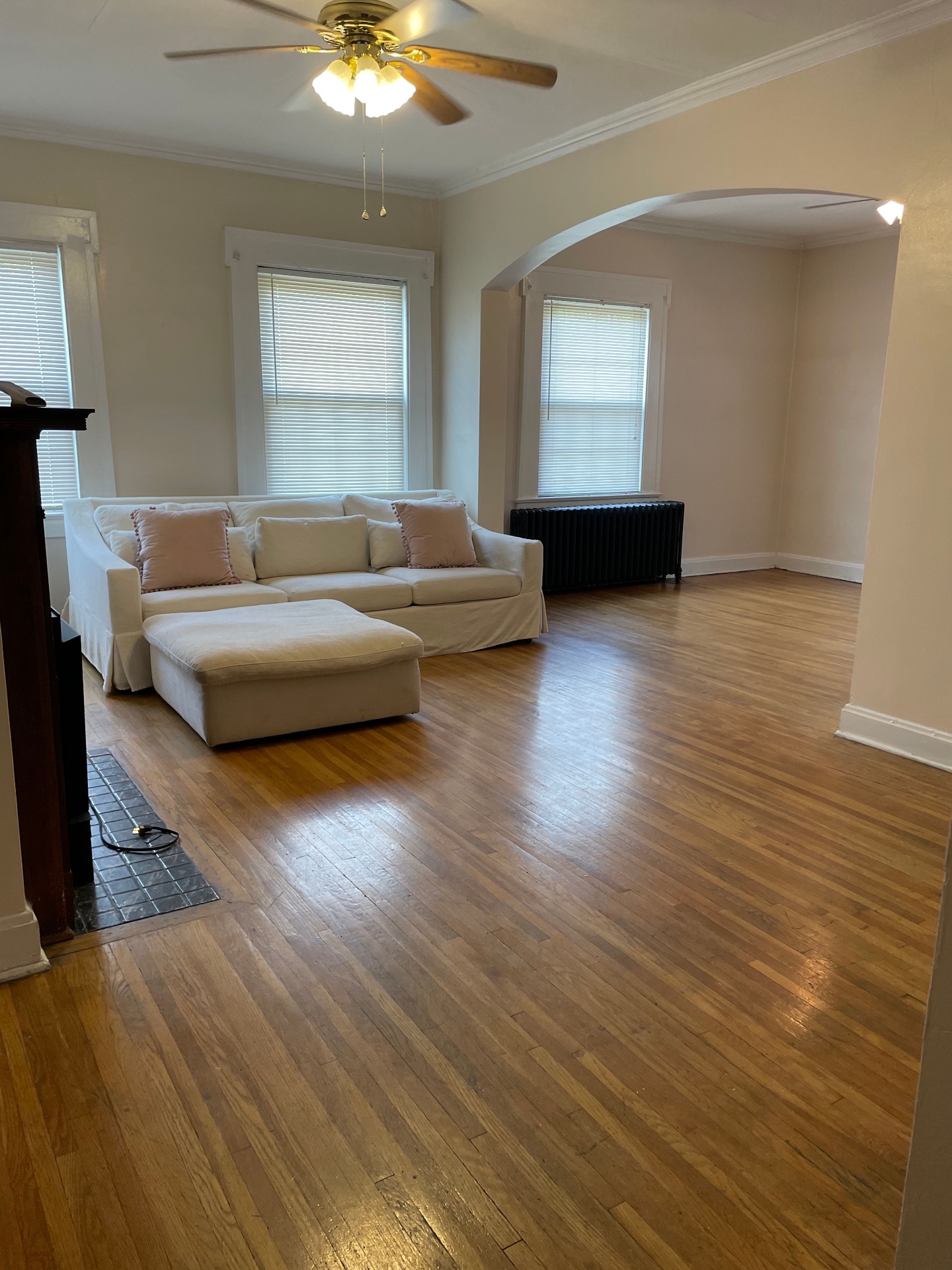 Unit E living room with open floor plan, arched entry, and hardwood floors