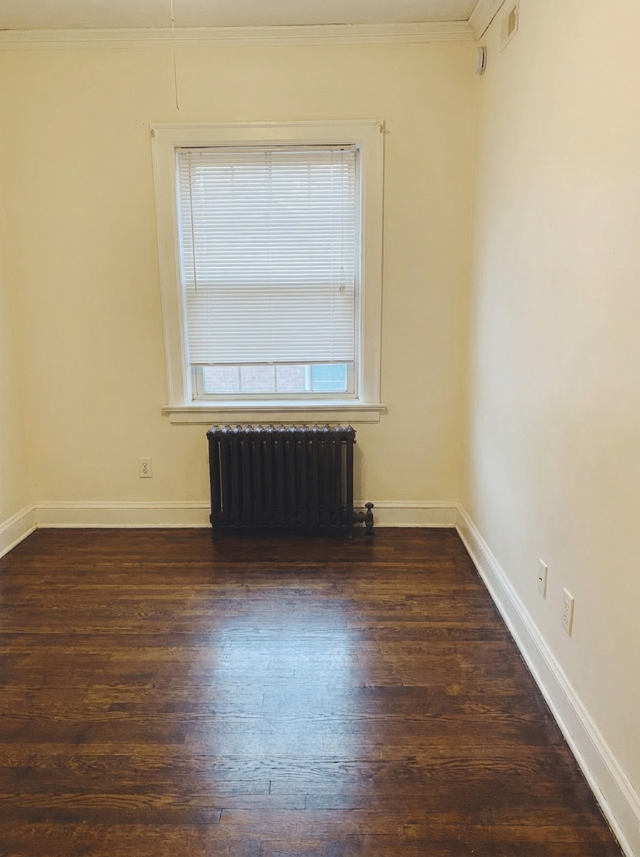 Unit H third bedroom / office with radiator and hardwood floors