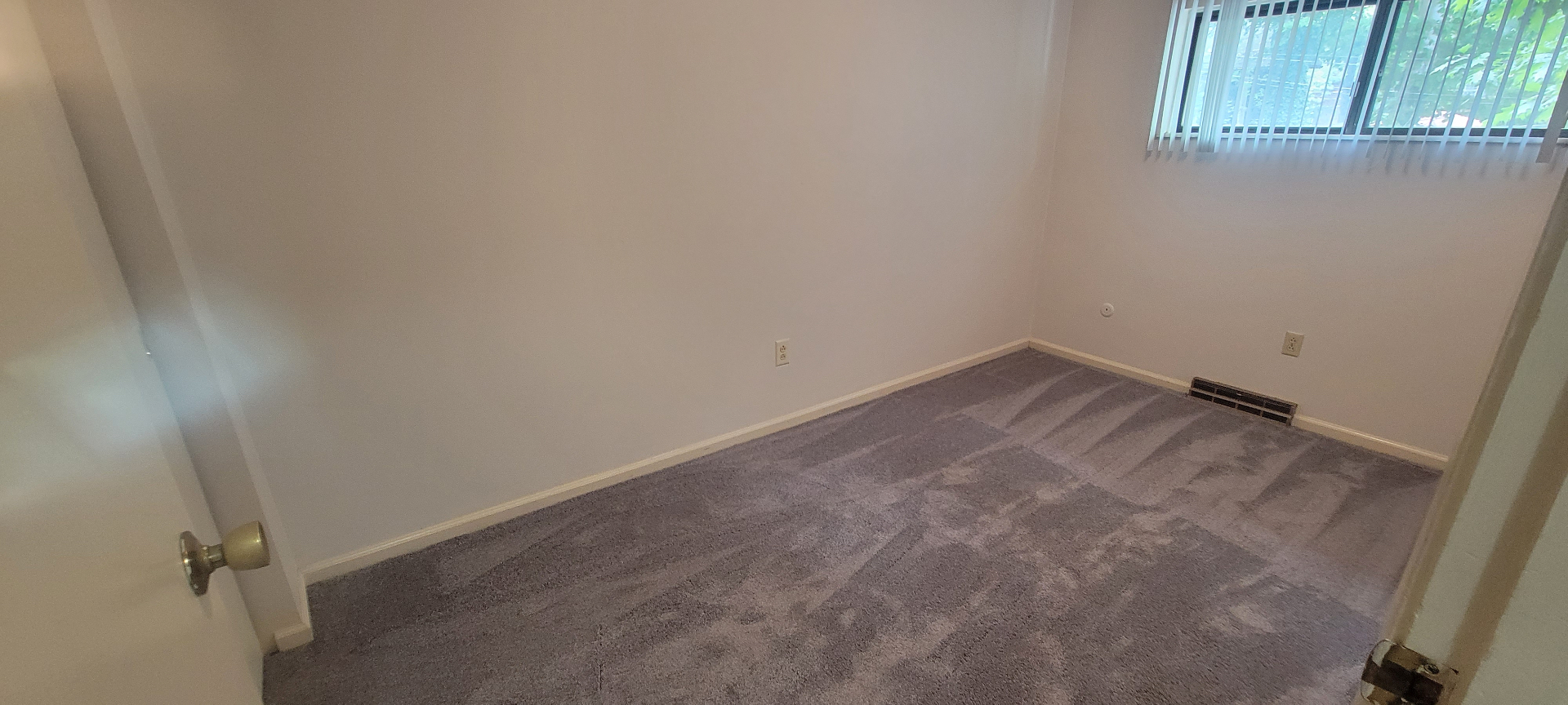 2022 Iuka Ave. bedroom with fresh grey carpet and window overlooking the greenery of the Iuka Ravine