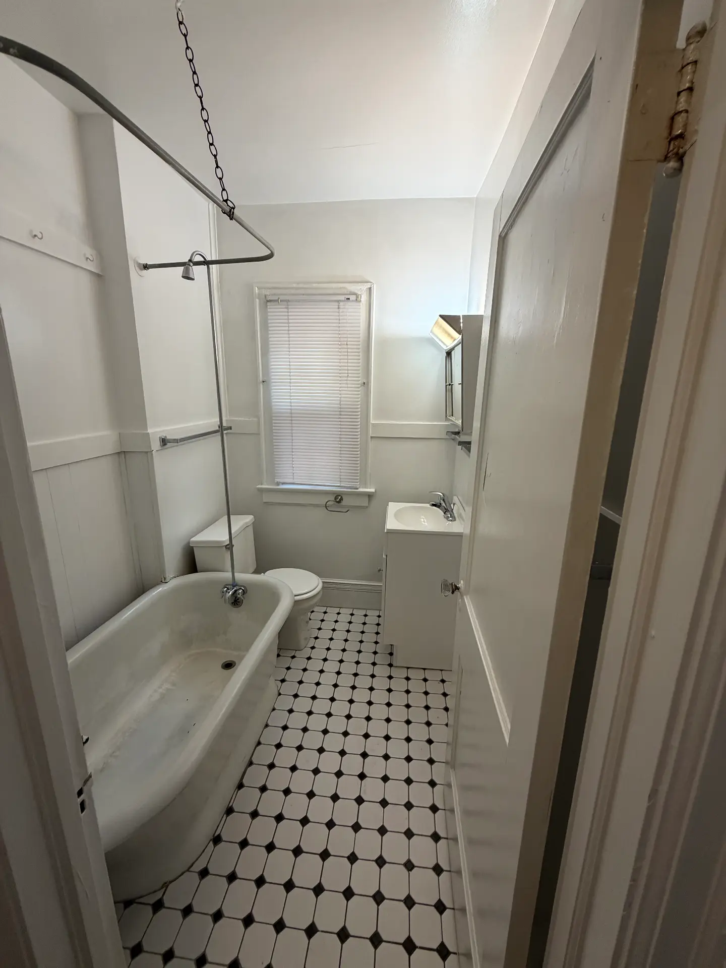 2048 Iuka Ave. D full bath with clawfoot tub, vanity sink, and black-and-white tile floor