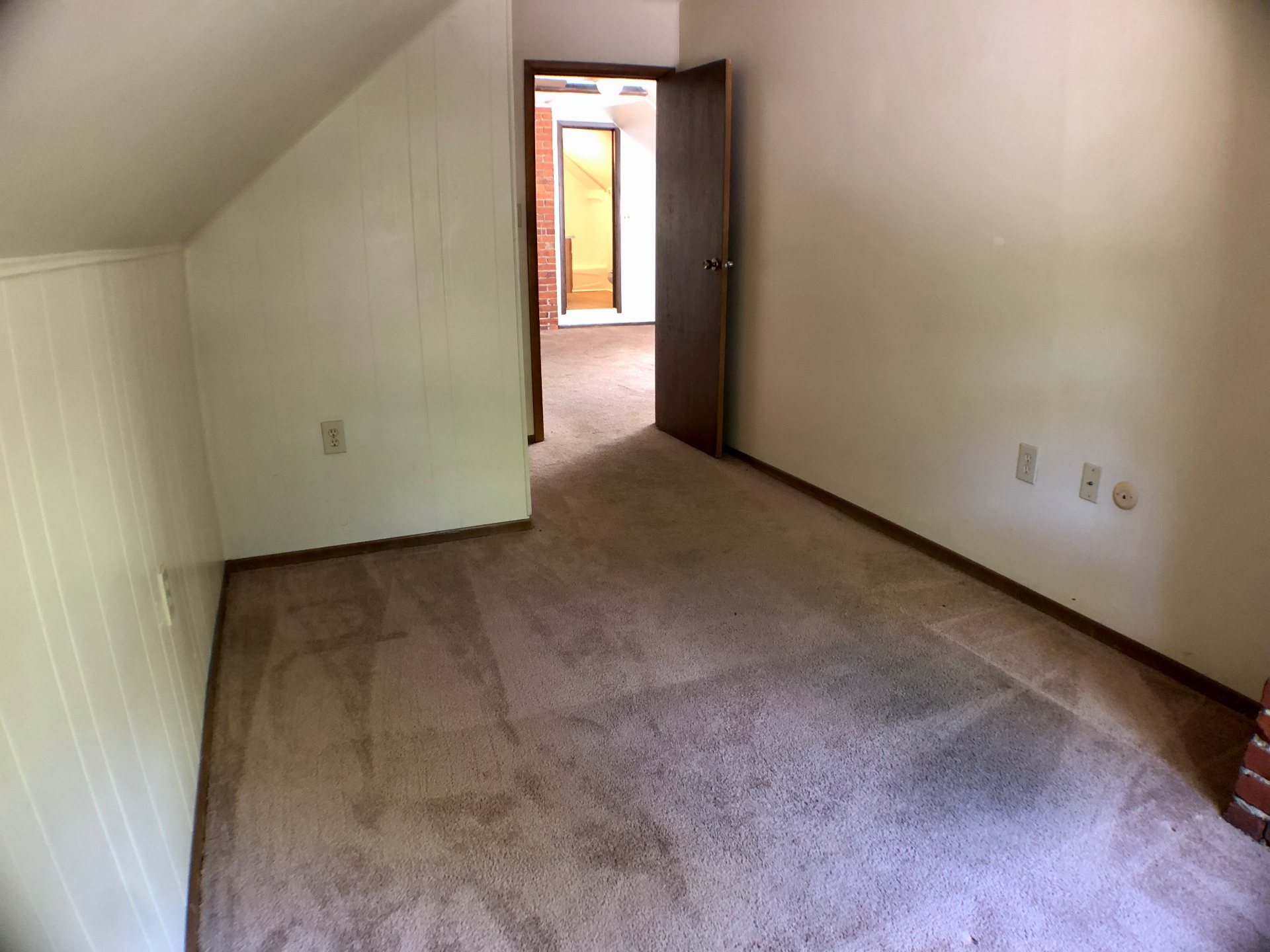Second bedroom with sloped attic ceiling, wainscoting, and carpet