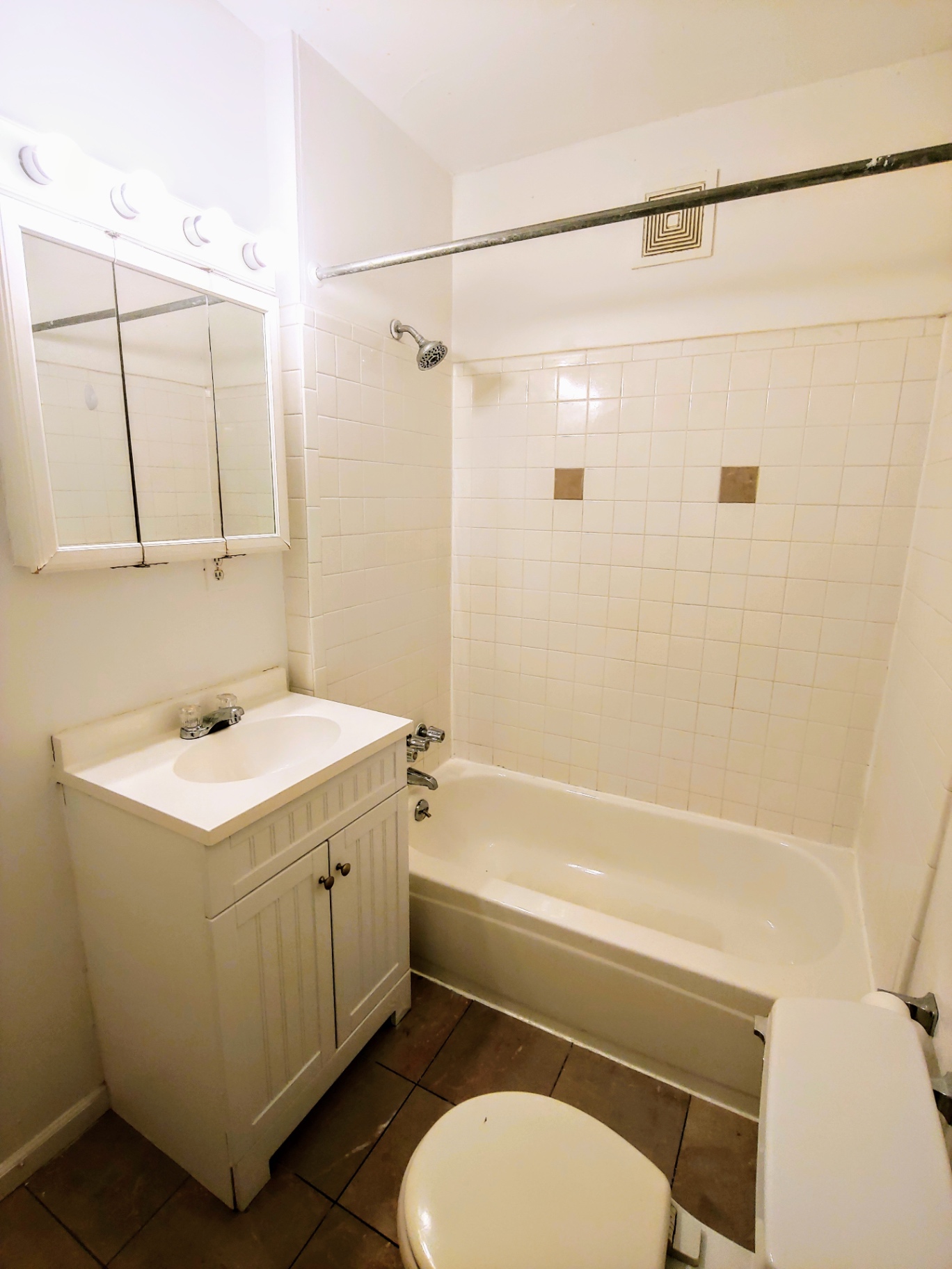 1818 Summit St. second bathroom with white tile tub surround, vanity, and mirrored medicine cabinet