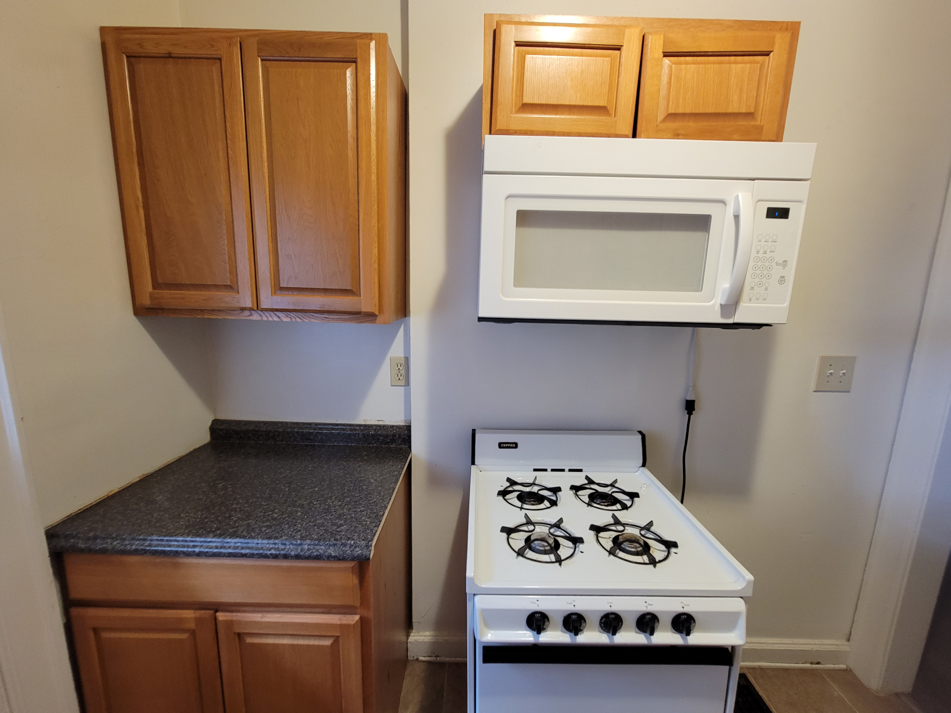 2048 Iuka Ave. B kitchen with gas range, over-the-range microwave, and warm wood cabinets