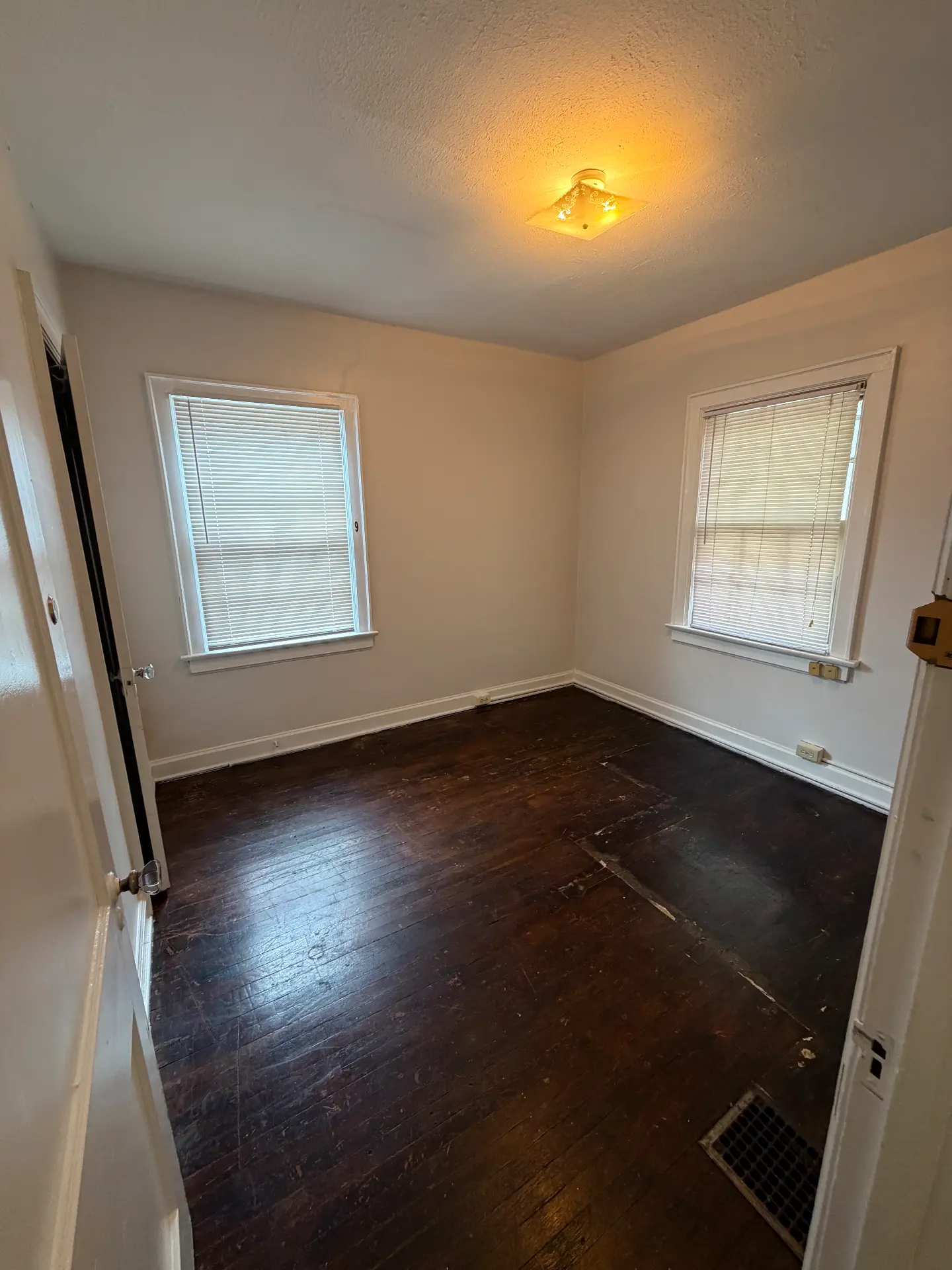 2048 Iuka Ave. D bedroom with two windows and dark hardwood floors