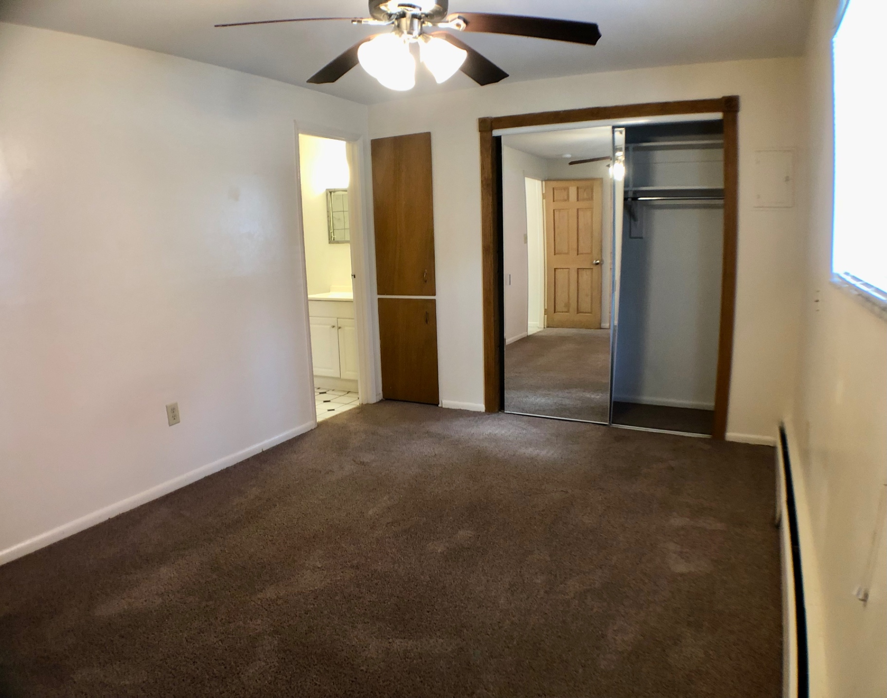1827 N 4th St. Unit 1 carpeted bedroom with mirrored closet, ceiling fan, and en-suite bath access