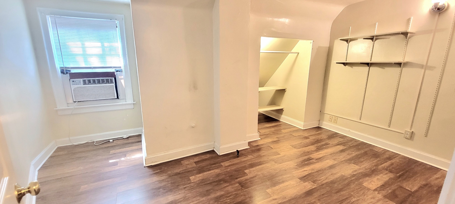 2044 Iuka Ave. D upper-level bedroom with luxury vinyl plank flooring, window AC, and built-in shelving nook