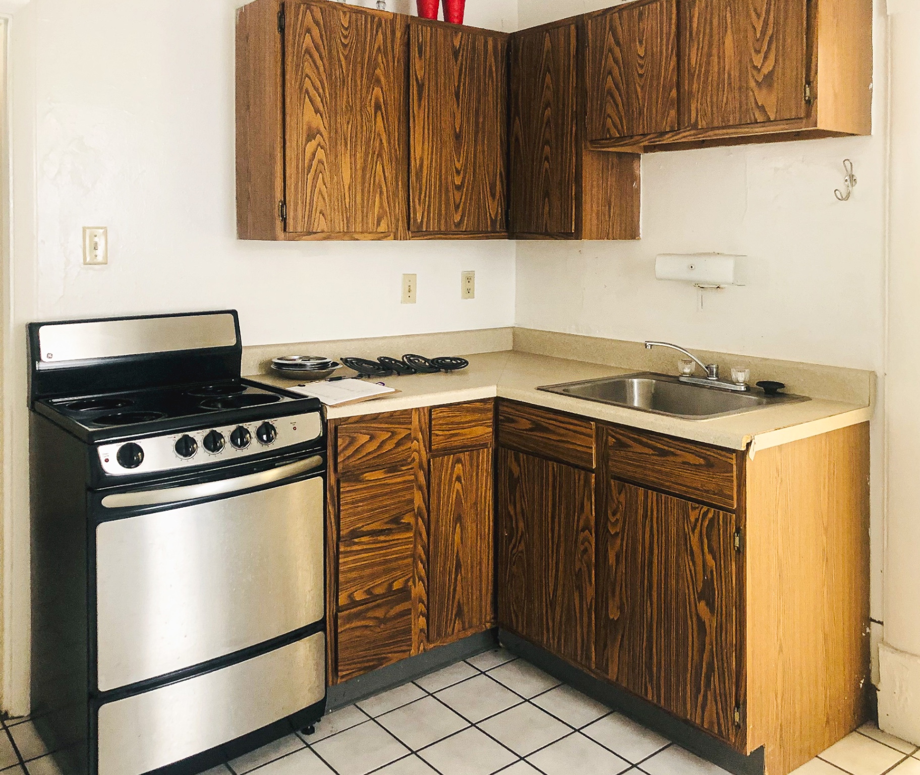 Rear unit kitchen corner with wood cabinets and electric range