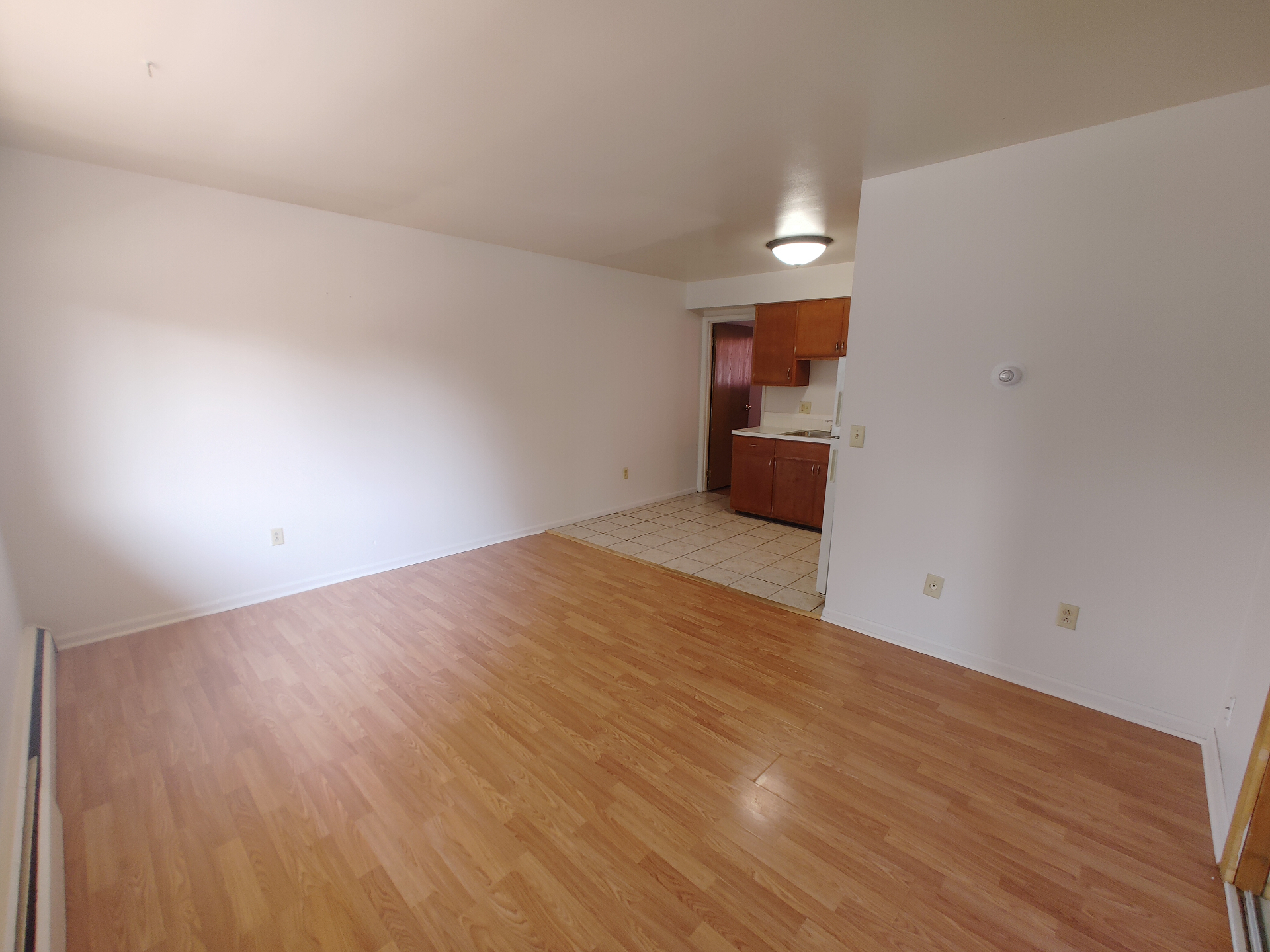 1827 N 4th St. Unit 5 spacious living room with wood-look flooring opening to tile kitchen