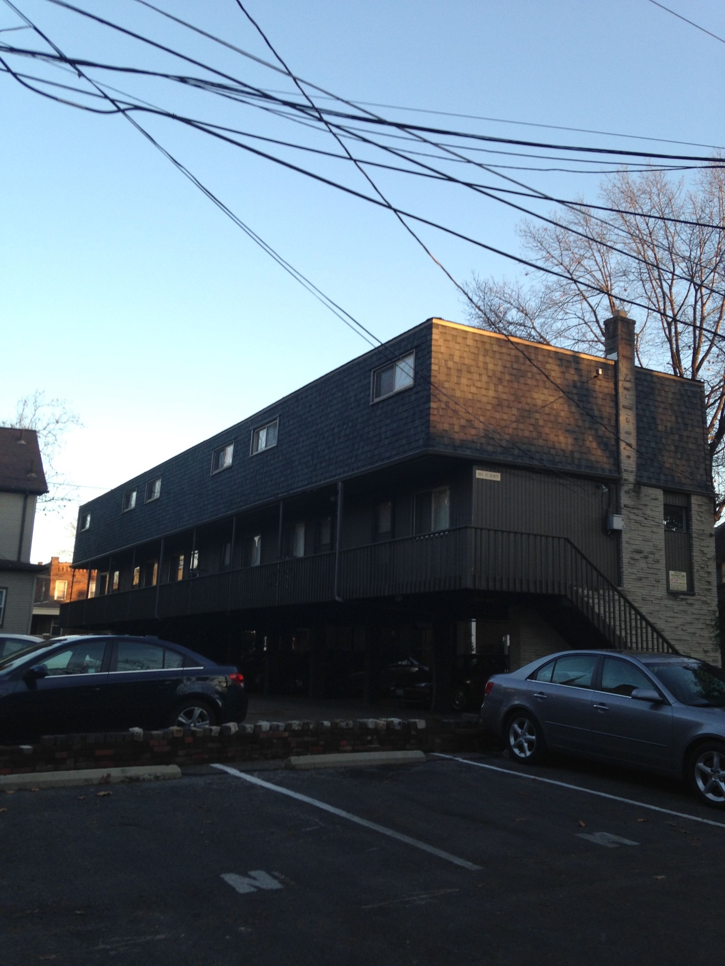 2011 Summit St. exterior — dark-shingled building with catwalk entries and carport parking