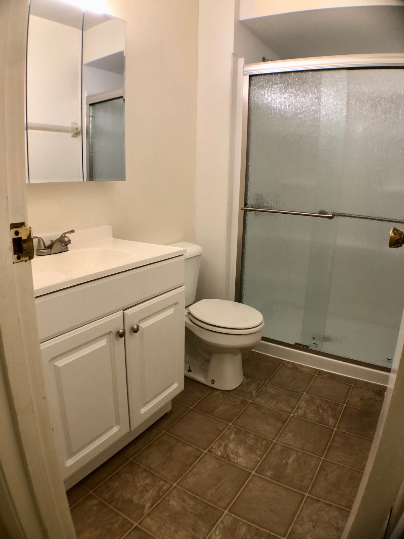 2020 Iuka Ave. bathroom with white vanity, medicine cabinet, and large glass-door shower