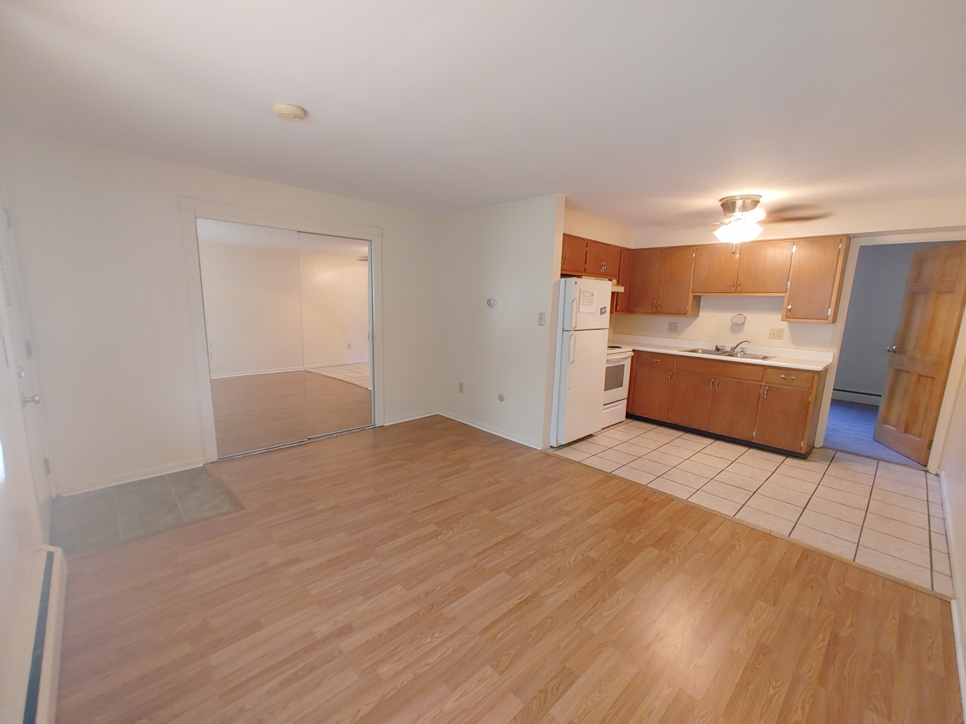 1827 N 4th St. Unit 3 open living area with wood-look flooring, mirrored closet doors, and kitchen