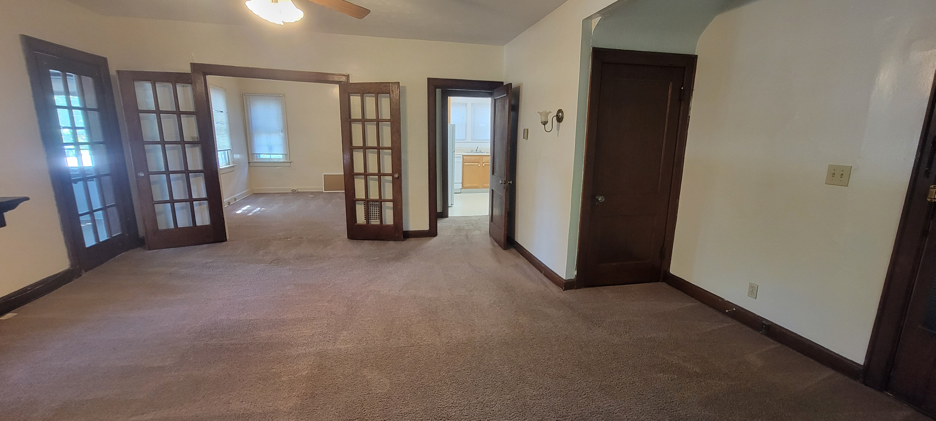 2054 Iuka Ave. A living area with original French doors and dark wood trim