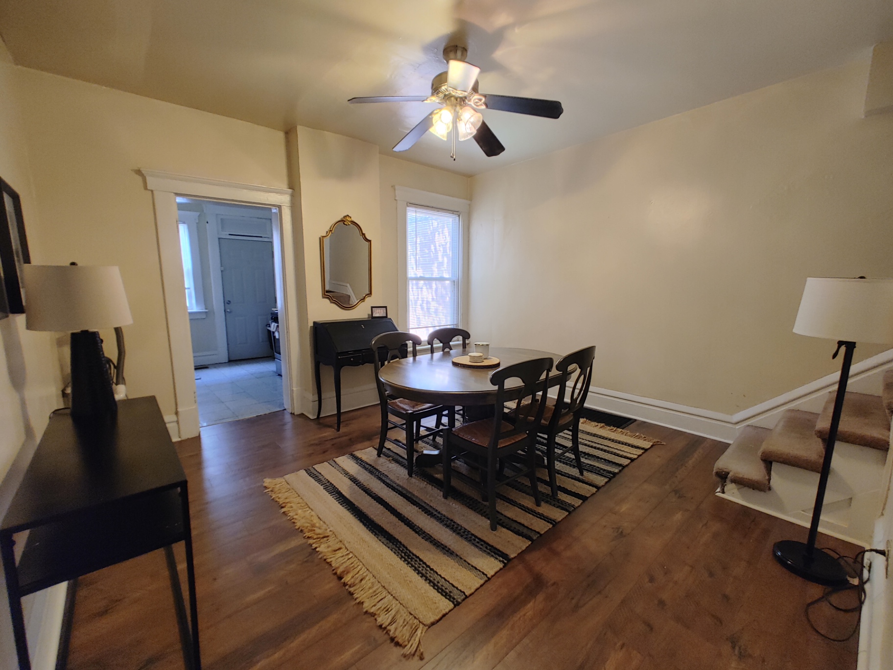 117 W 9th dining room with hardwood floors, ceiling fan and staircase