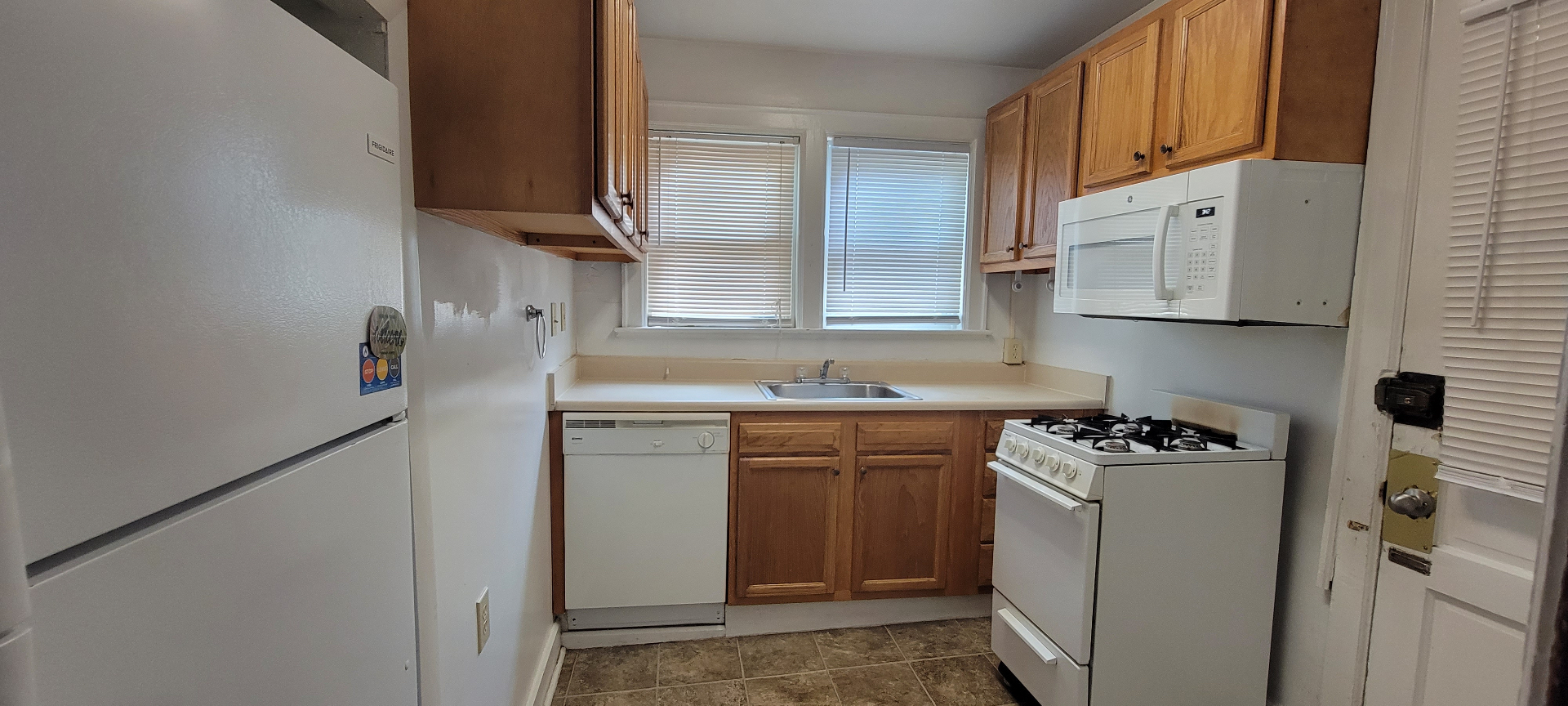 2054 Iuka Ave. C kitchen with gas range, dishwasher, full-size fridge, and oak cabinetry
