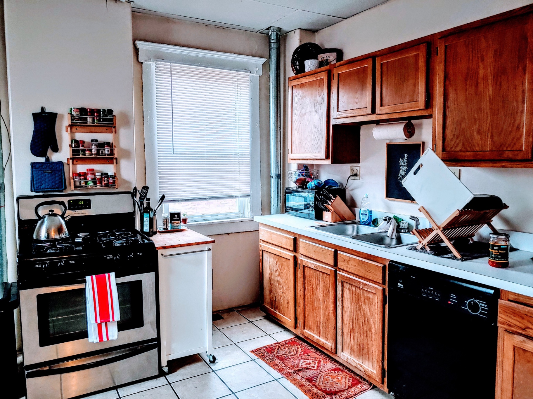 113 W 9th kitchen with gas range, oak cabinets and tile floor