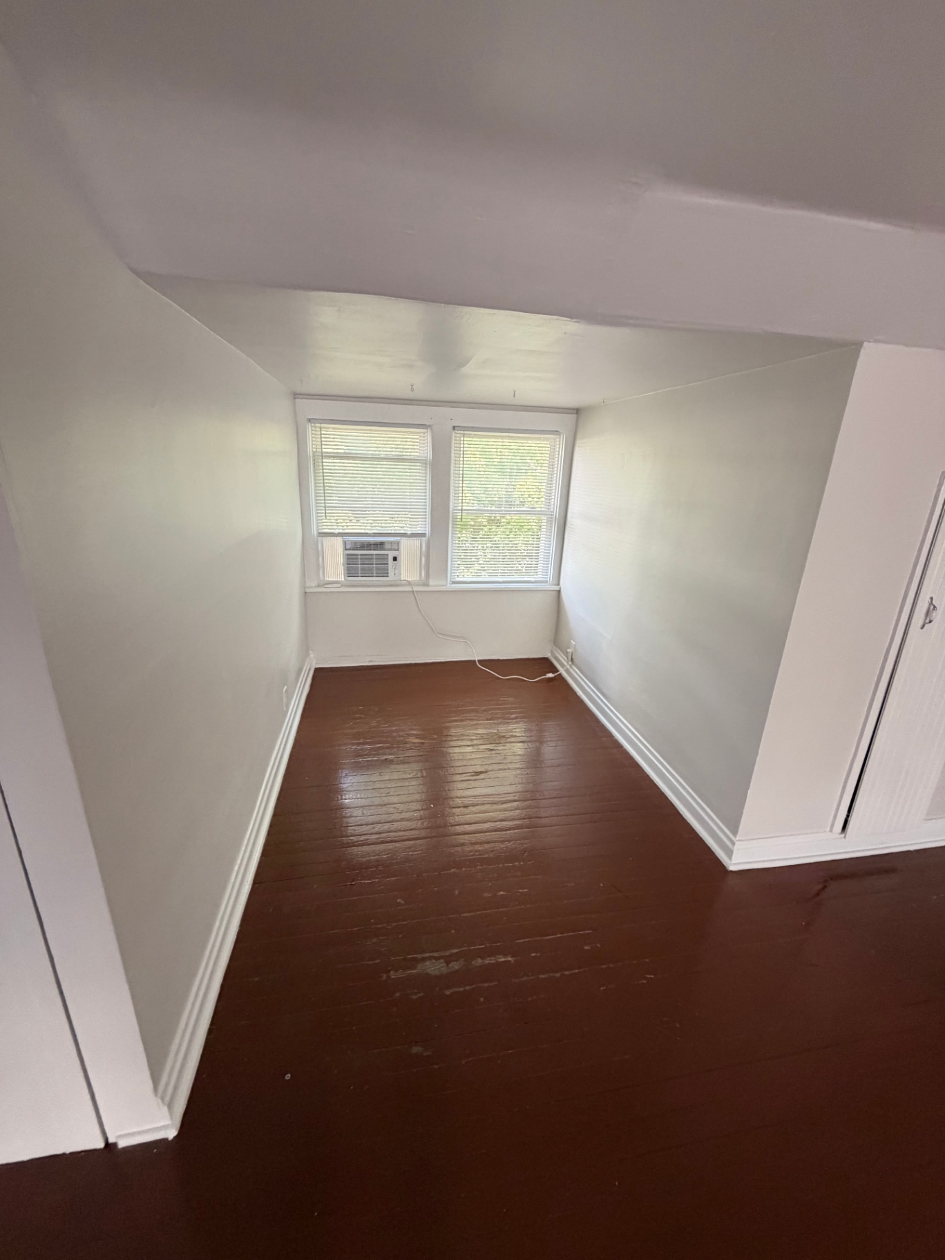 3340 Chestnut Upstairs bedroom nook with painted hardwood floors and window AC