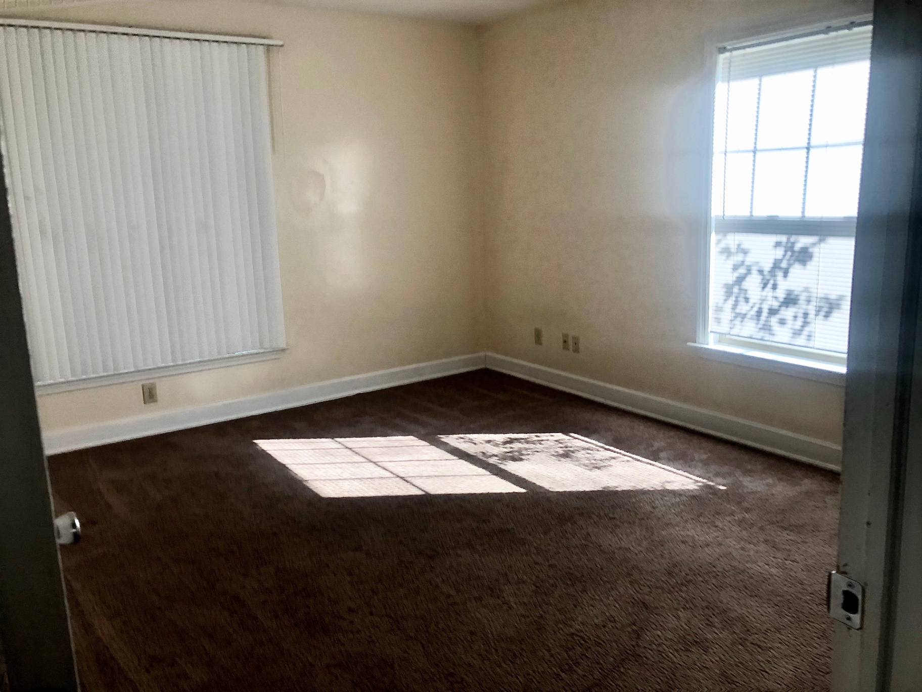 2034 Iuka Ave A carpeted bedroom with two windows and vertical blinds