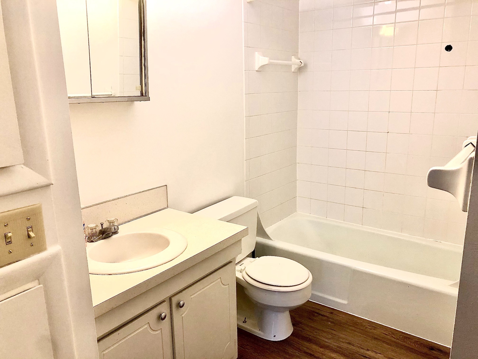 2011 Summit St. Unit D bathroom with tub/shower, white tile, and plank flooring
