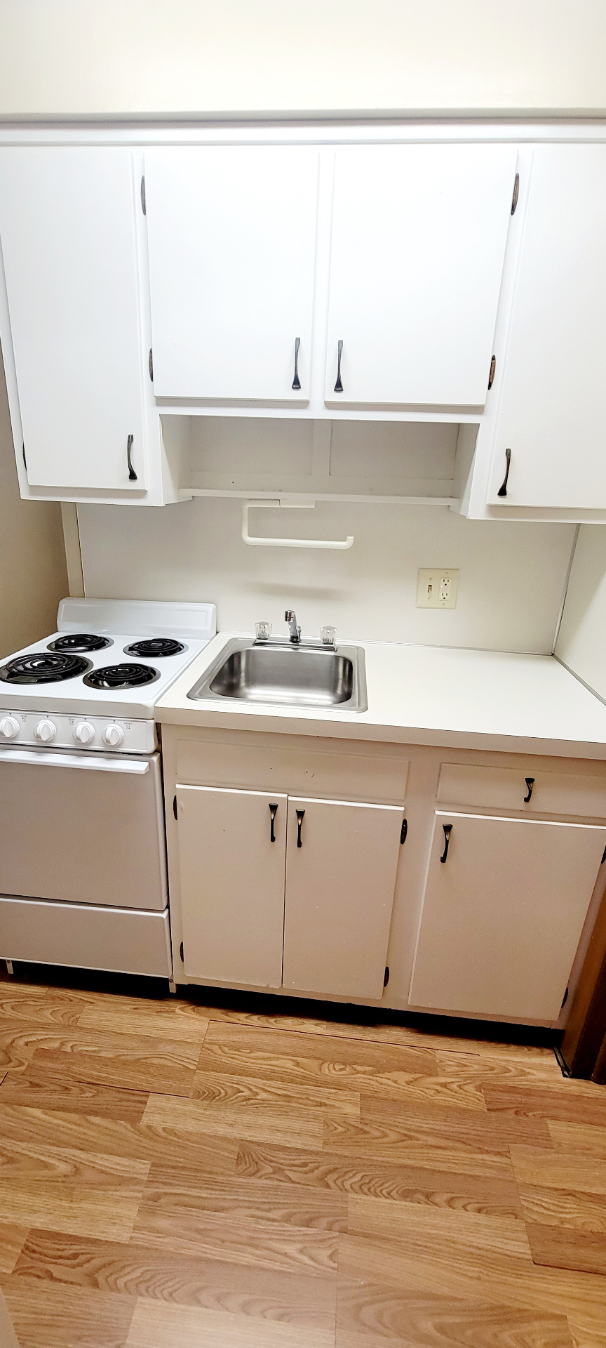 2040 Iuka Ave. 3A compact kitchen with electric range, sink, and white cabinetry