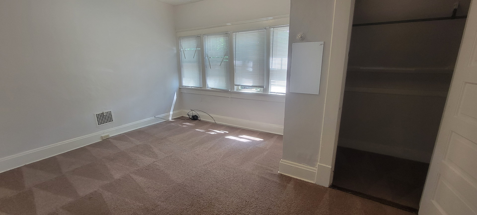 2015 Summit St. carpeted bedroom with bank of windows and sliding barn door closet