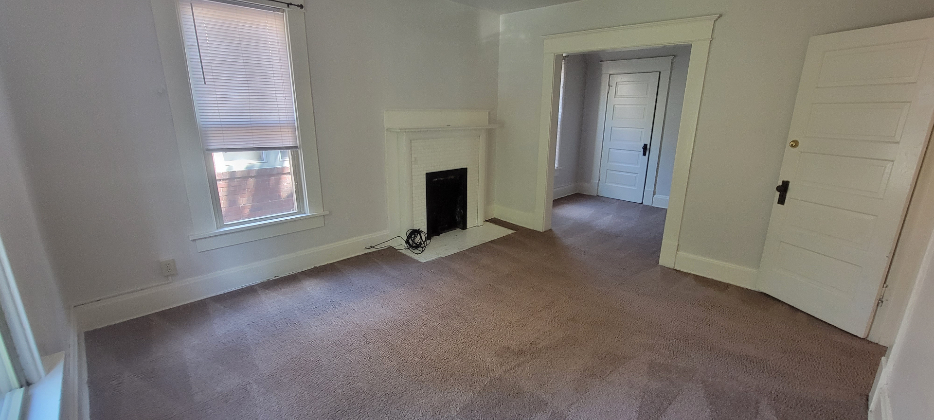 2015 Summit St. bedroom with decorative white fireplace and doorway to adjoining room