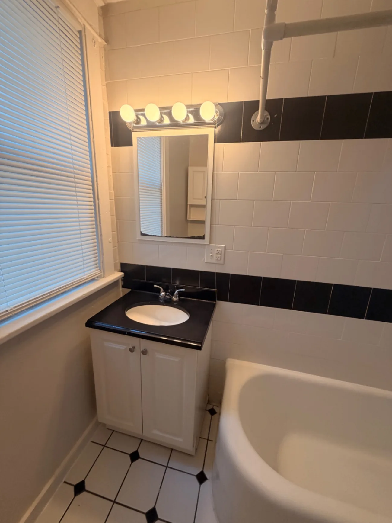 1816 Summit St. bathroom vanity with black countertop and vintage tile surround
