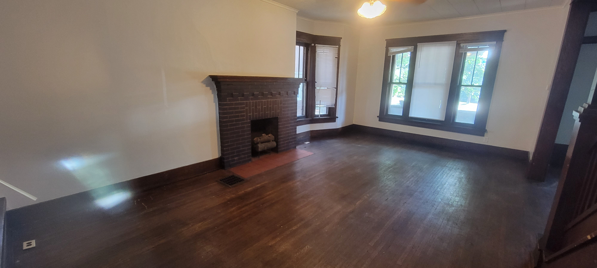 2015 Summit St. living room with brick fireplace, hardwood floors, and bay windows