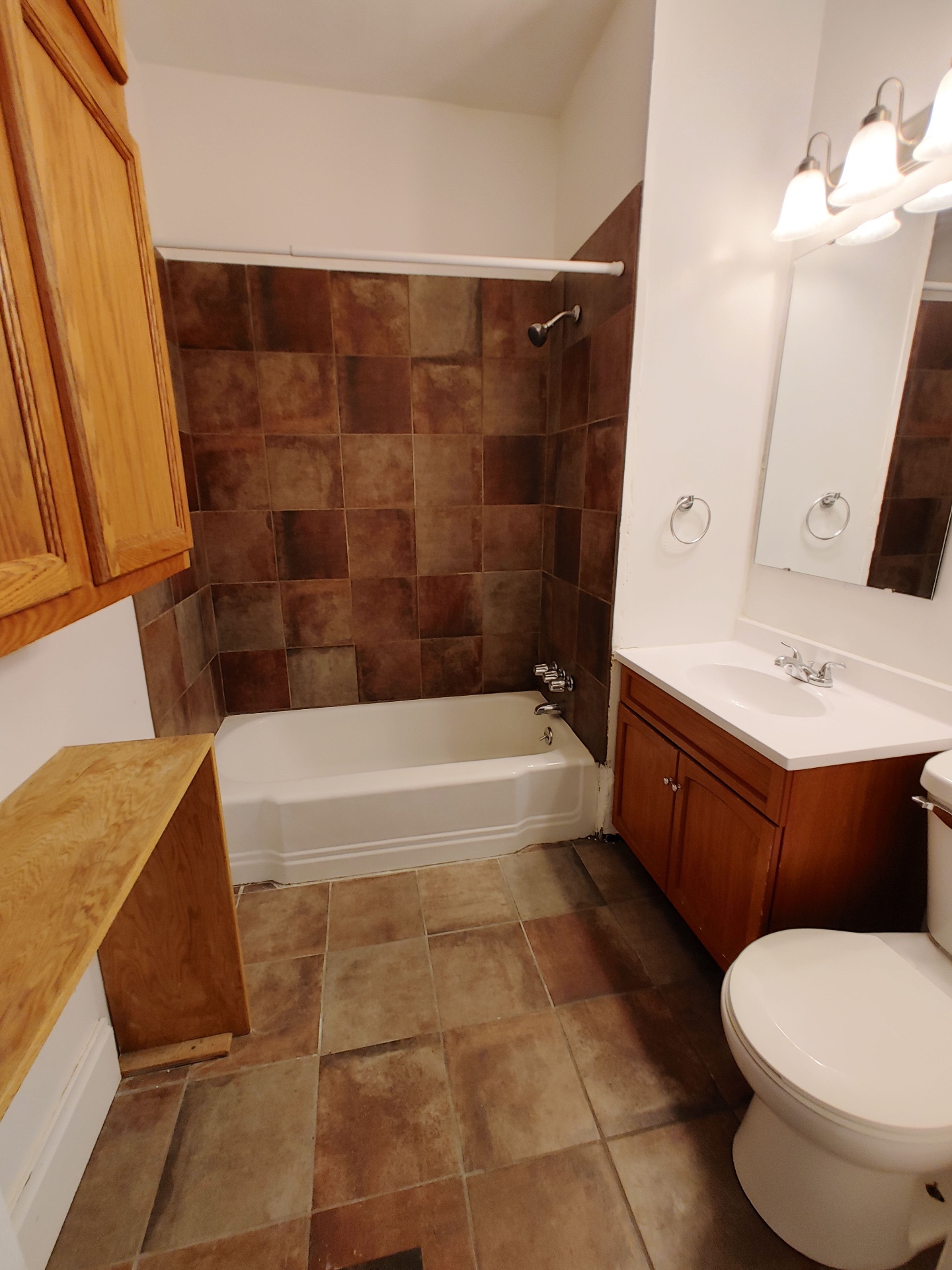374 A E 14th Ave. bathroom with soaking tub, brown tile surround, and wood vanity