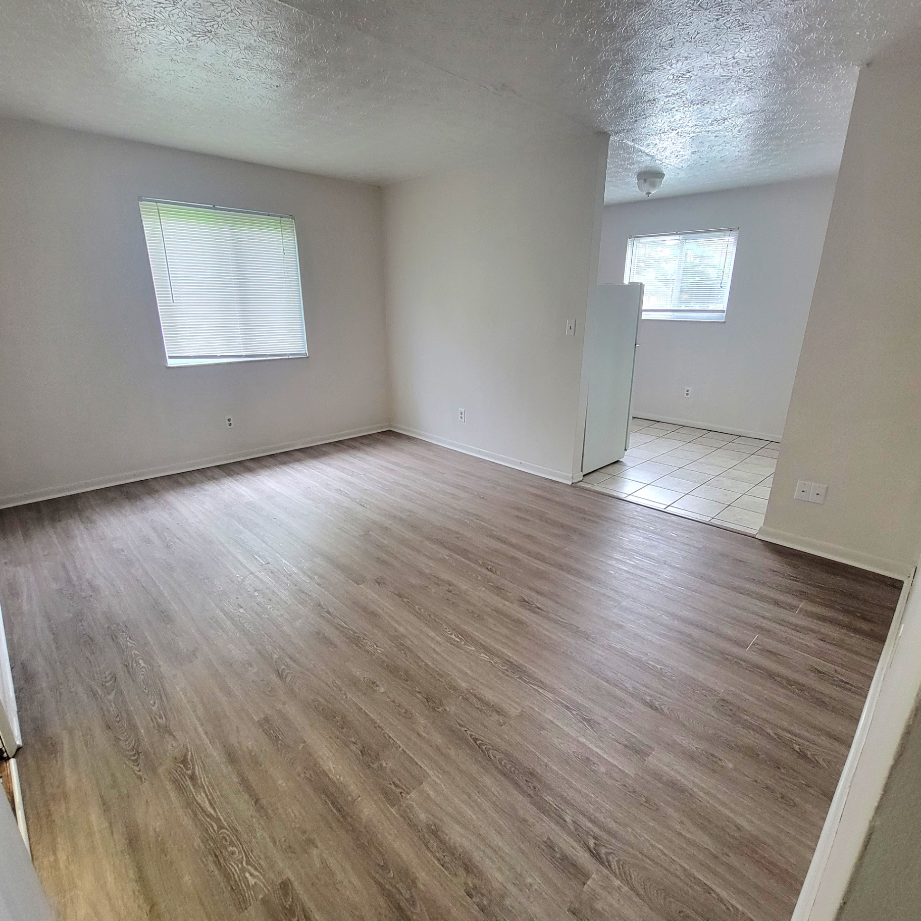 2150 N 4th St. Unit E living room with plank flooring opening to tile kitchen