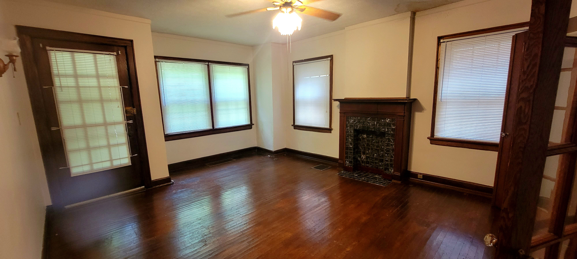 2048 Iuka Ave. A living room with tiled fireplace, front entry, and warm hardwood floors