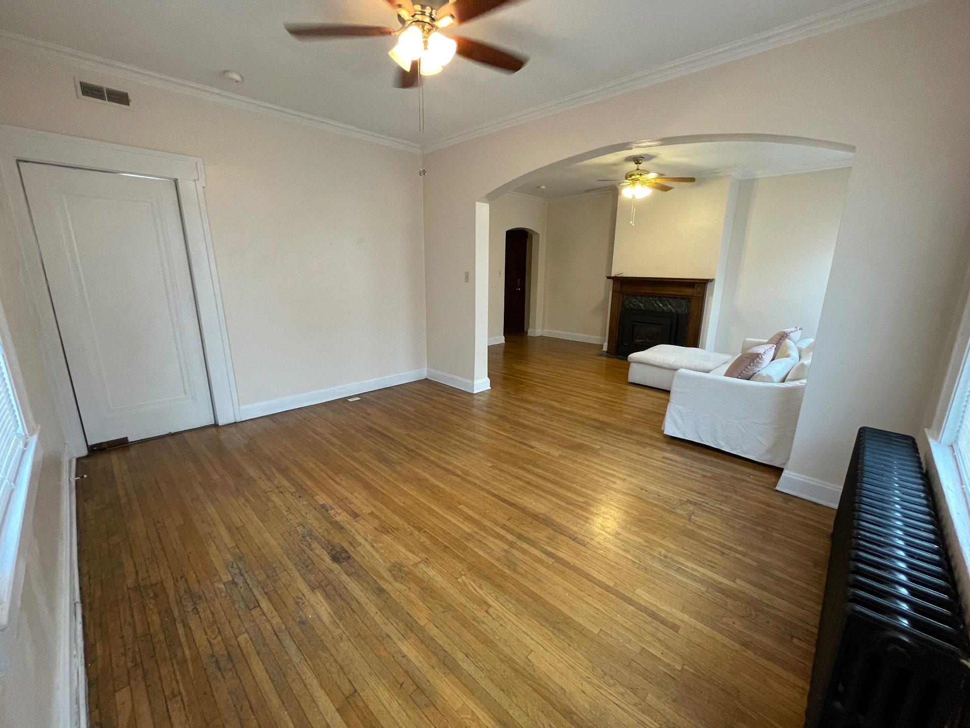 Unit E open living and dining area with arched entry to fireplace room