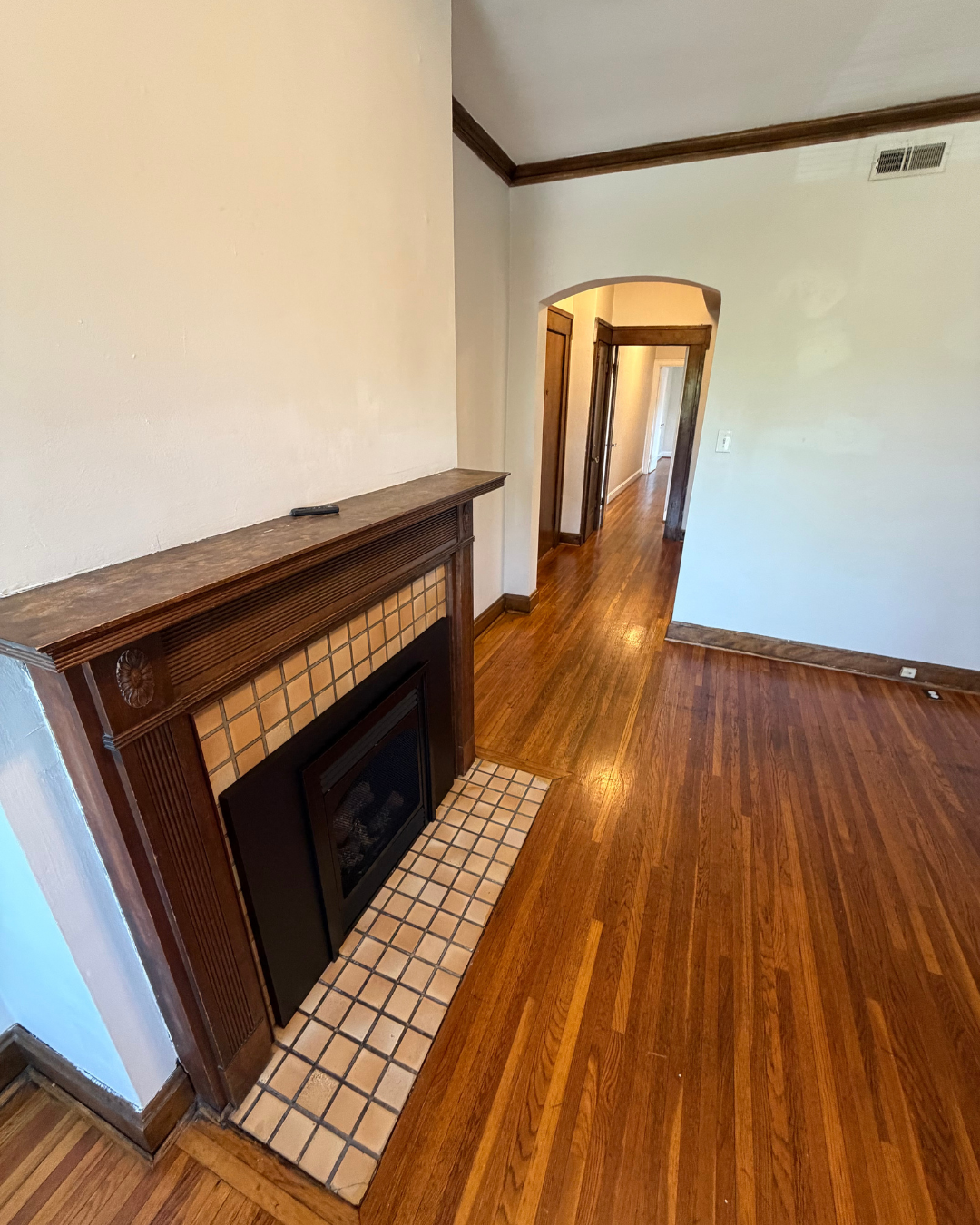 Living room with gas fireplace, wood mantel, and hardwood floors