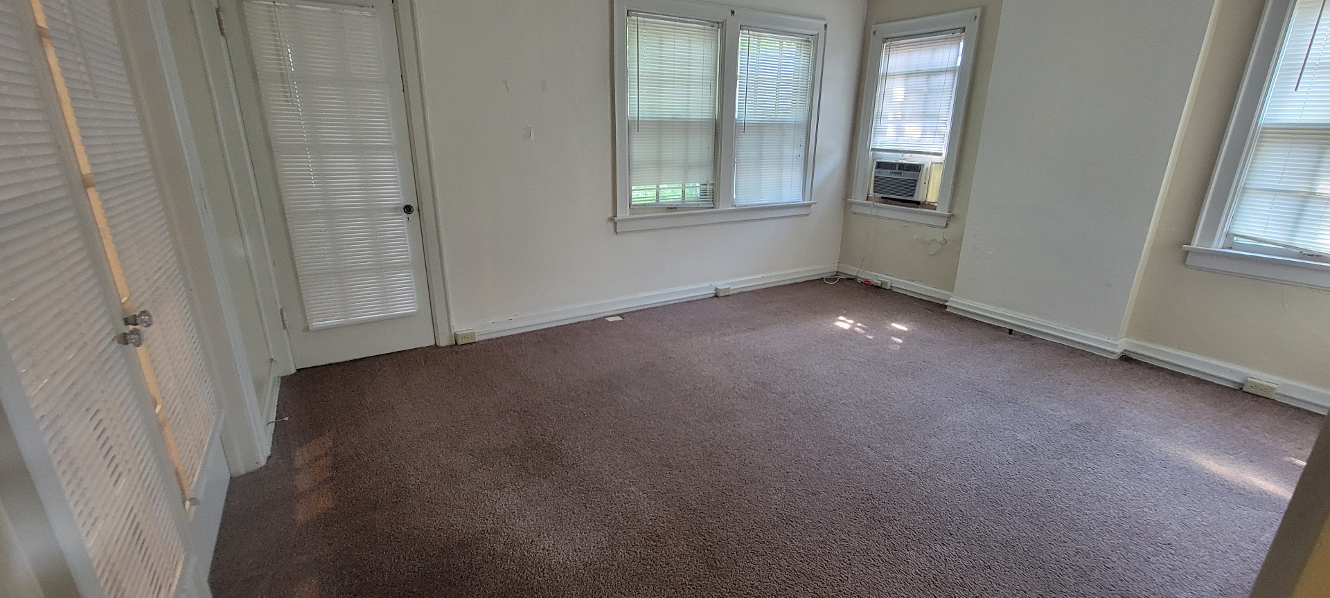 2044 Iuka Ave. D enclosed sunroom with wraparound windows, window AC, and neutral carpet