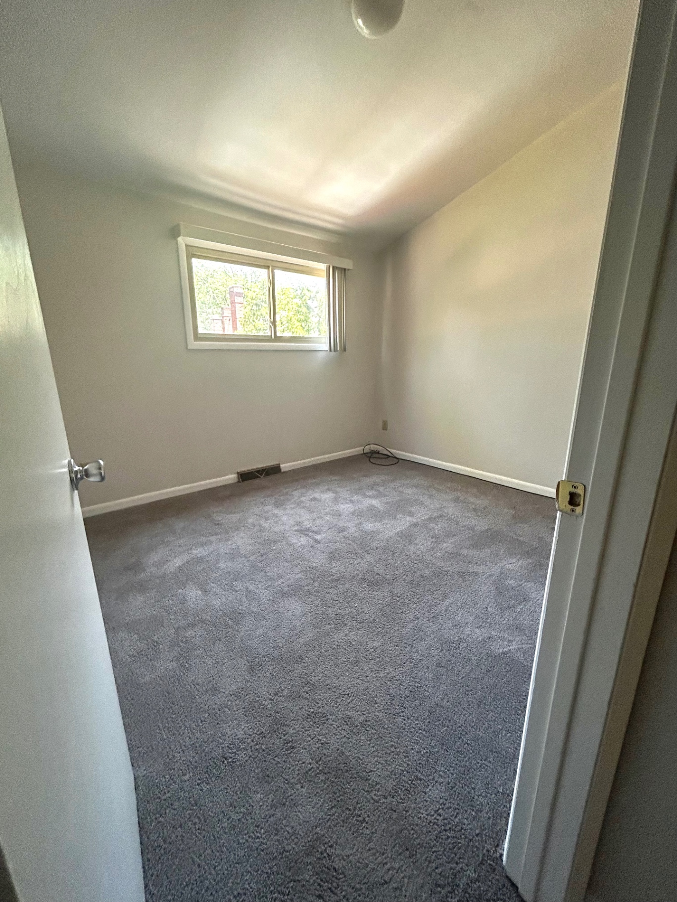 2011 Summit St. Unit E carpeted bedroom with large window and soft natural light