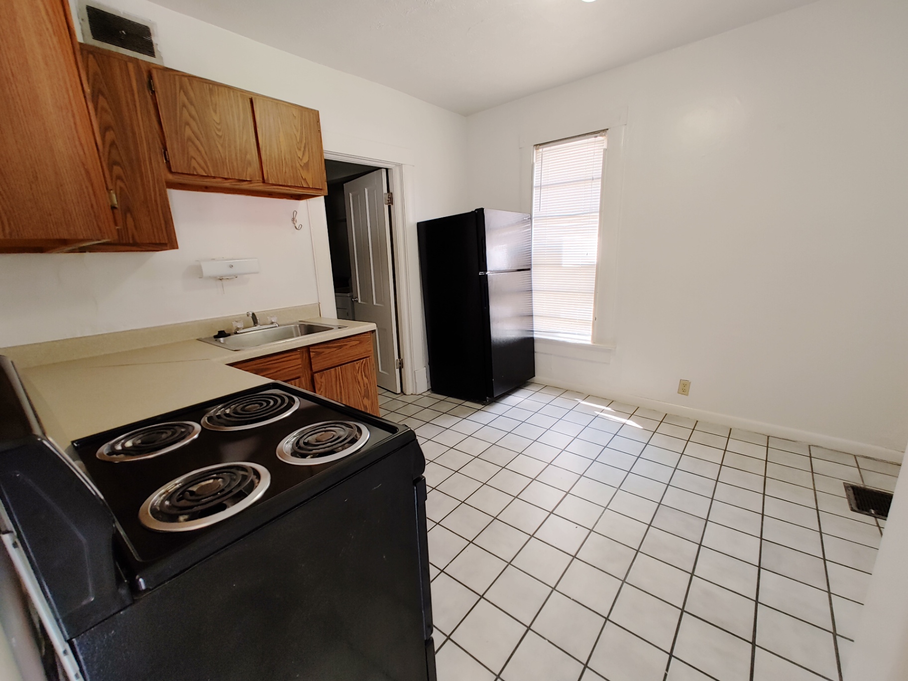 Rear unit eat-in kitchen with tile floor, full-size fridge and electric range