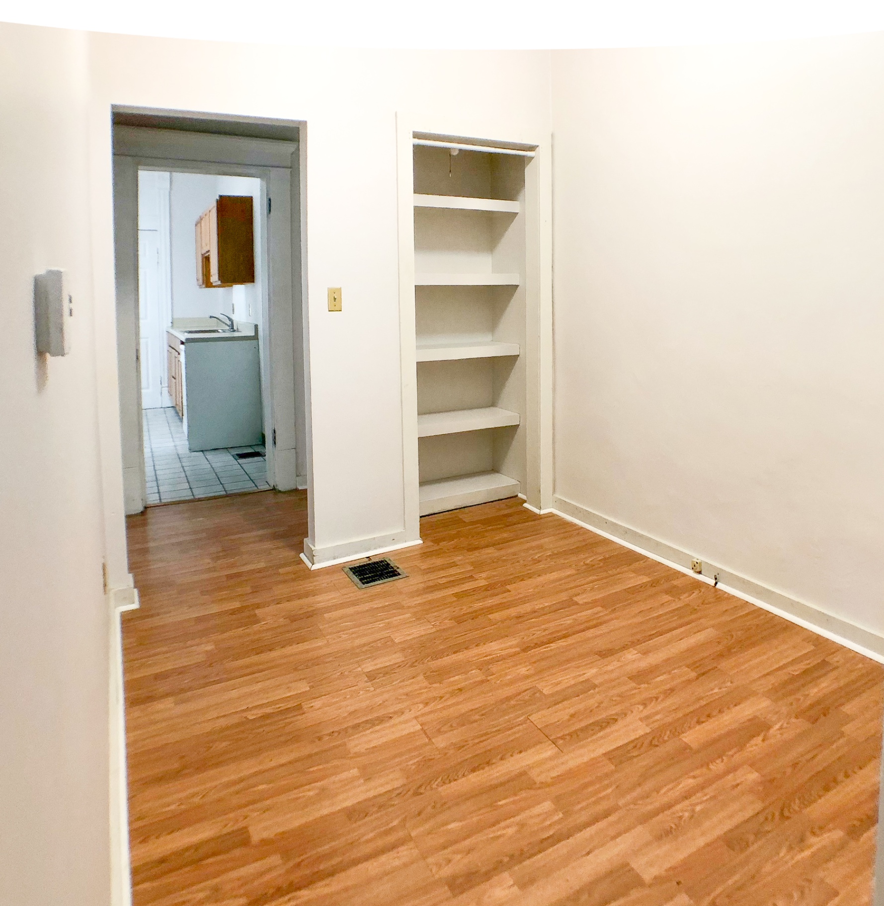 Unit A second bedroom with hardwood floors and large window