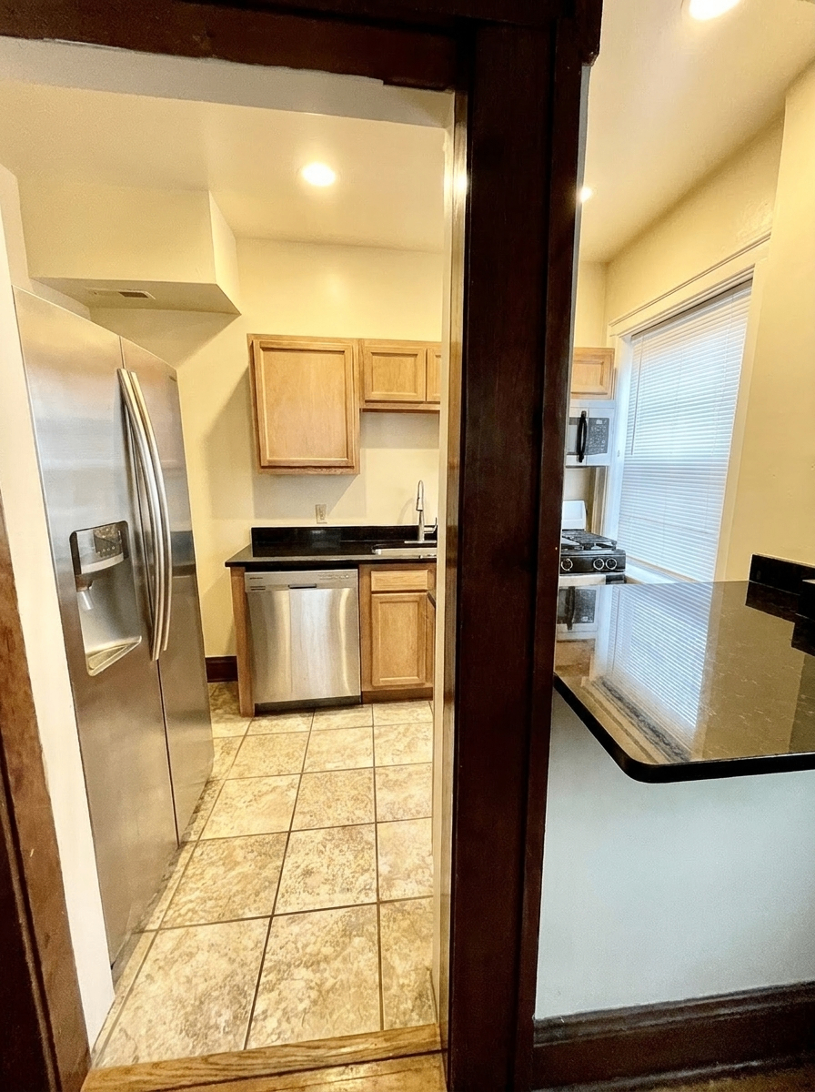 Unit D kitchen entry showing stainless steel appliances and granite counters