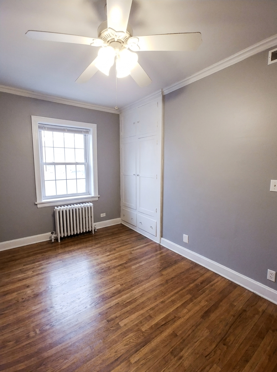 Unit C bedroom with built-in white cabinets and ceiling fan