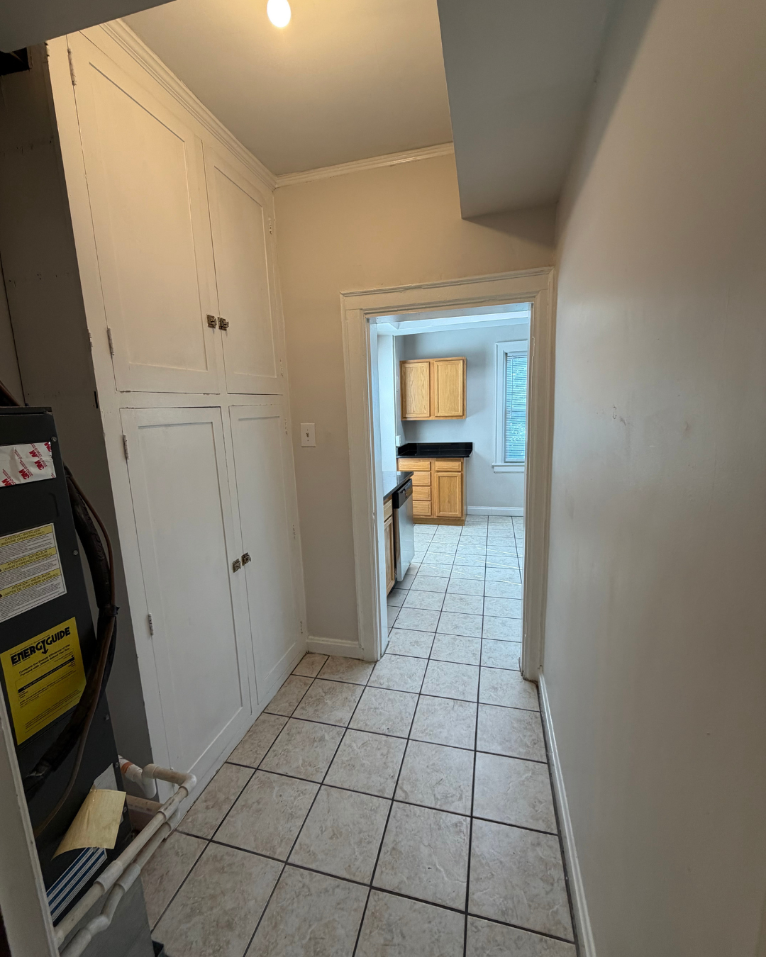 Pantry with built-in cabinets and passage to kitchen