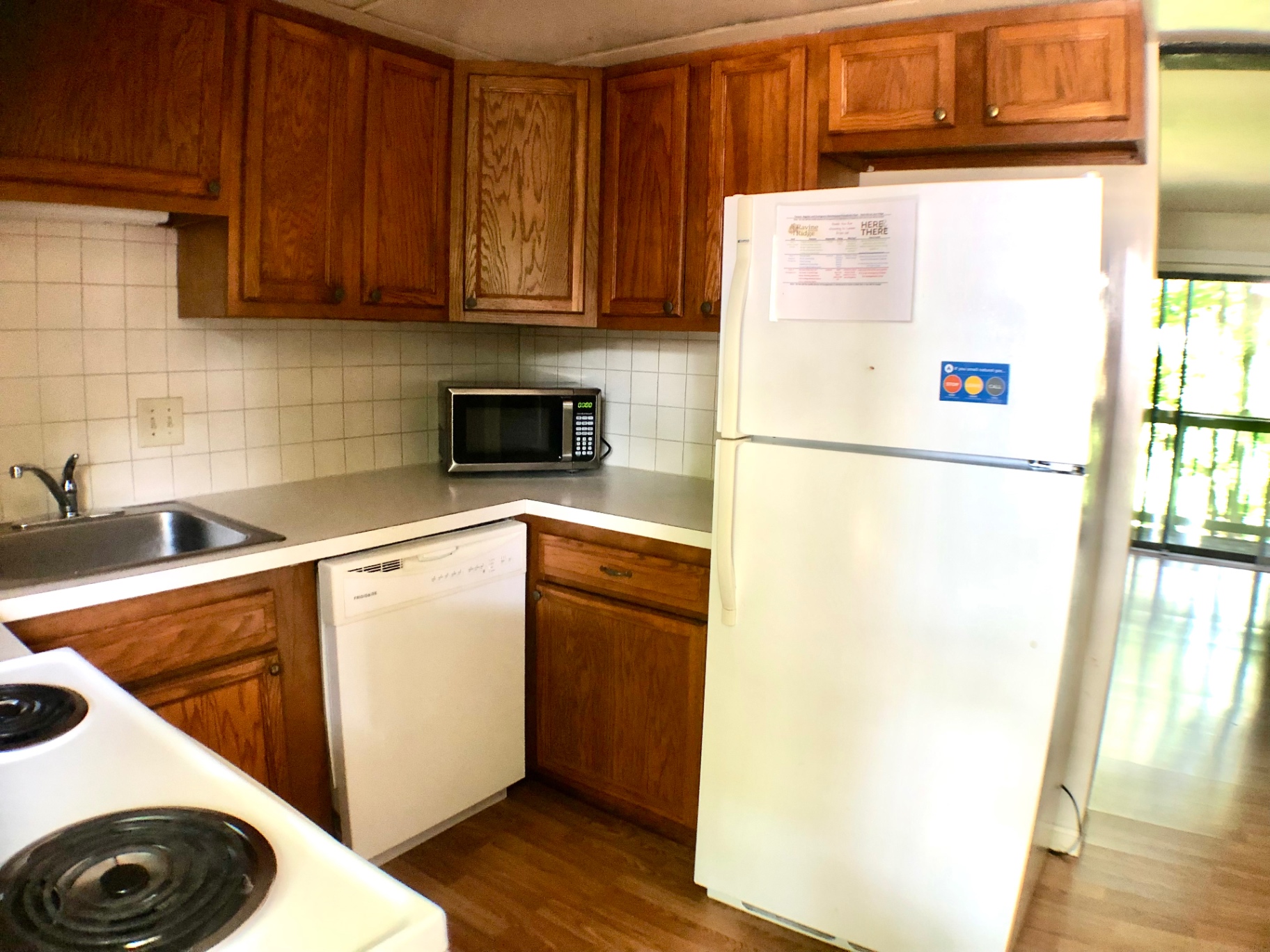 2018 Iuka Ave. kitchen corner with wraparound counters, dishwasher, microwave, and full-size refrigerator