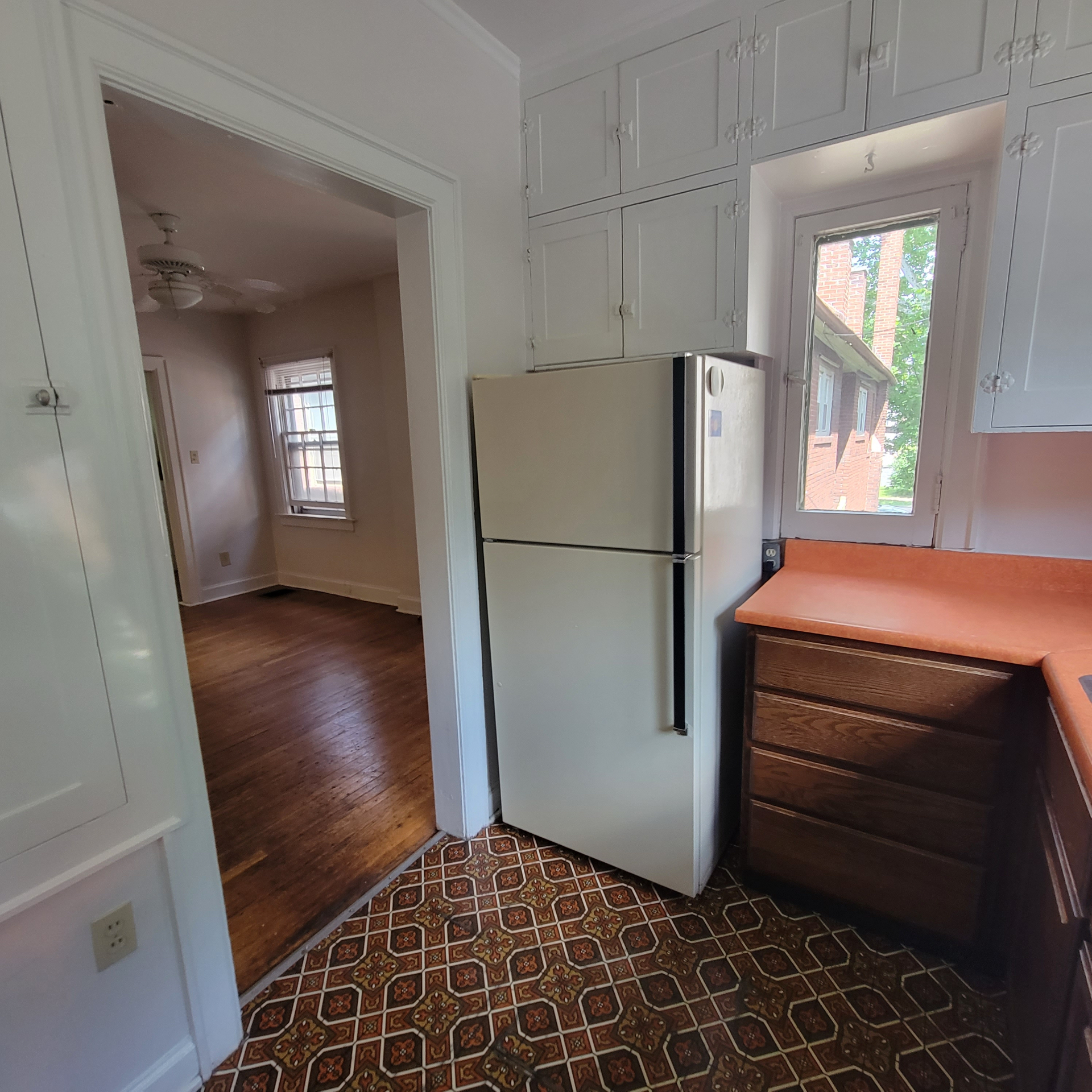 2048 Iuka Ave. C kitchen with full-size refrigerator, built-in cabinetry, and view toward adjacent room