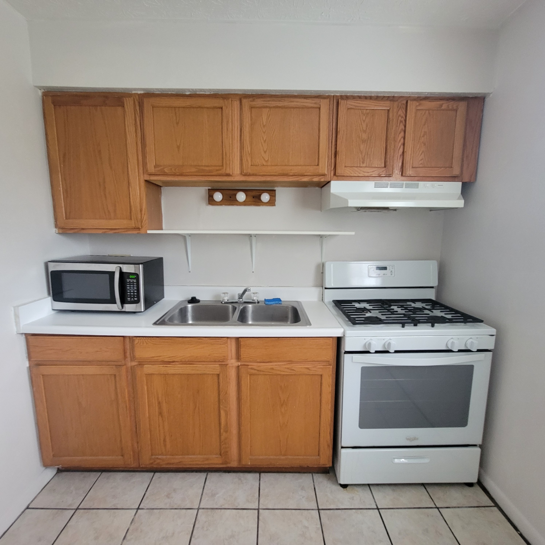 2150 N 4th St. Unit E kitchen with oak cabinets, gas range, and stainless microwave