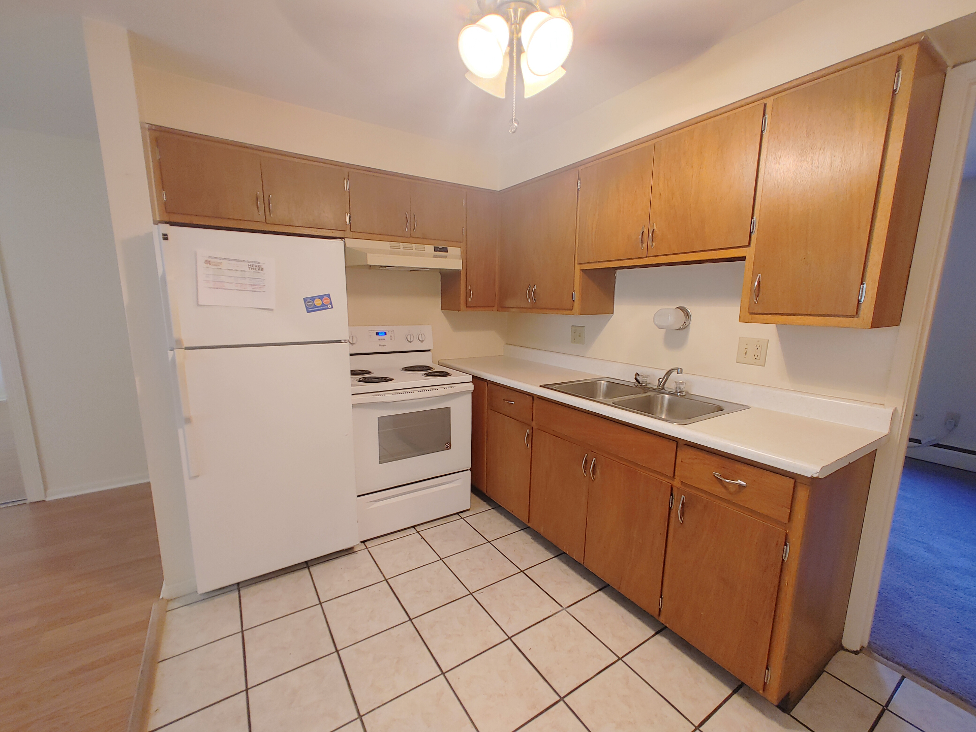 1827 N 4th St. Unit 3 kitchen with oak cabinets, white appliances, double sink, and tile floor