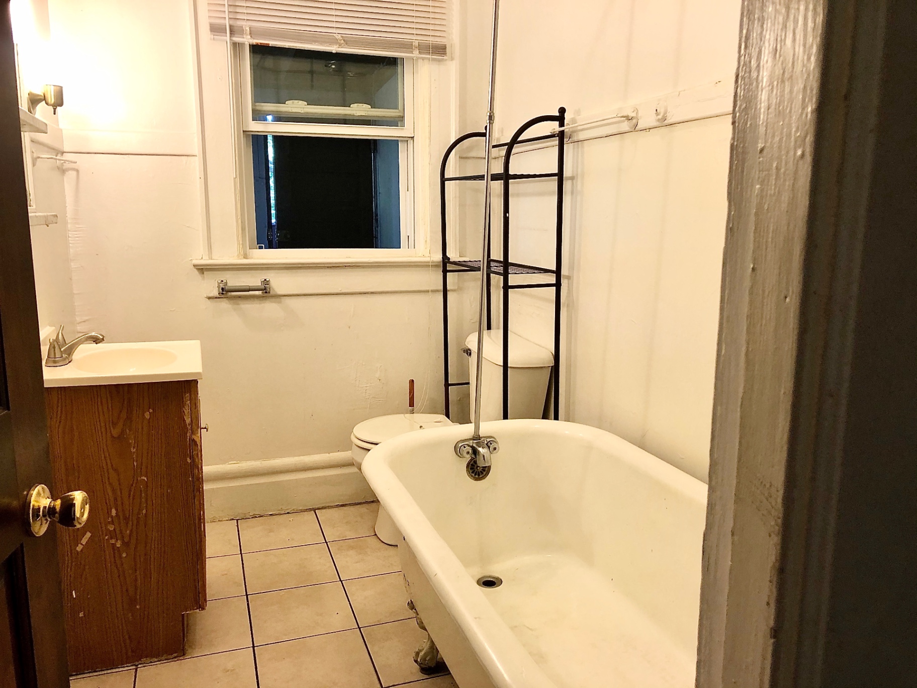 372 B E 14th Ave. bathroom with clawfoot tub, pedestal-style vanity, and tile floor
