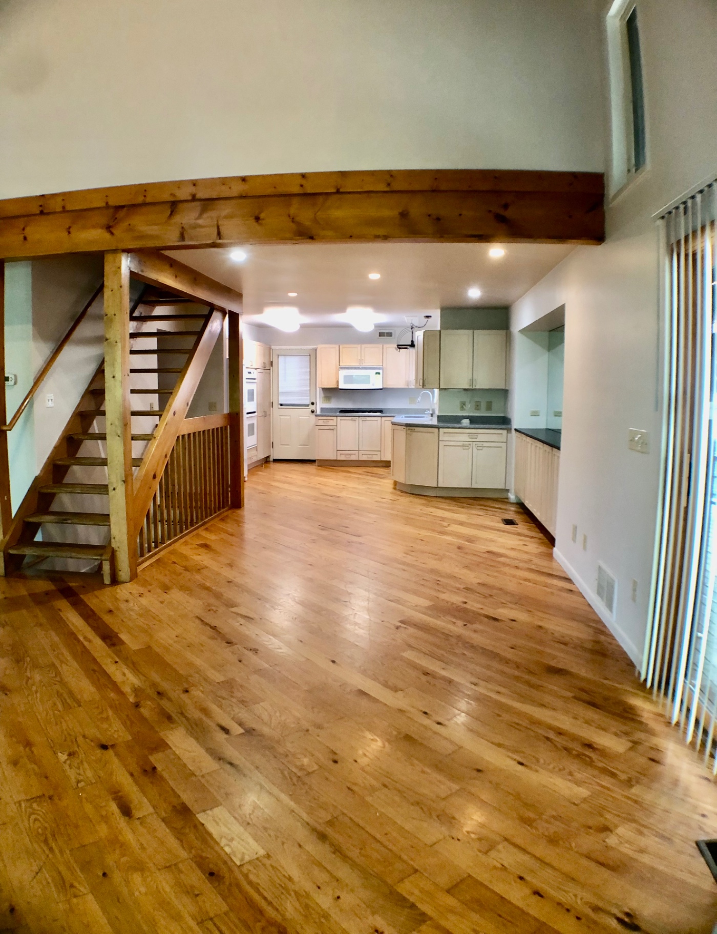 2040 Iuka Ave House open living/dining area with hardwood floors and stairs to loft
