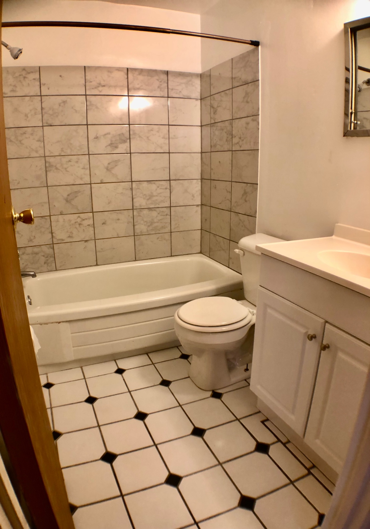 1827 N 4th St. Unit 1 bathroom with marble-tiled tub surround and checkered tile floor