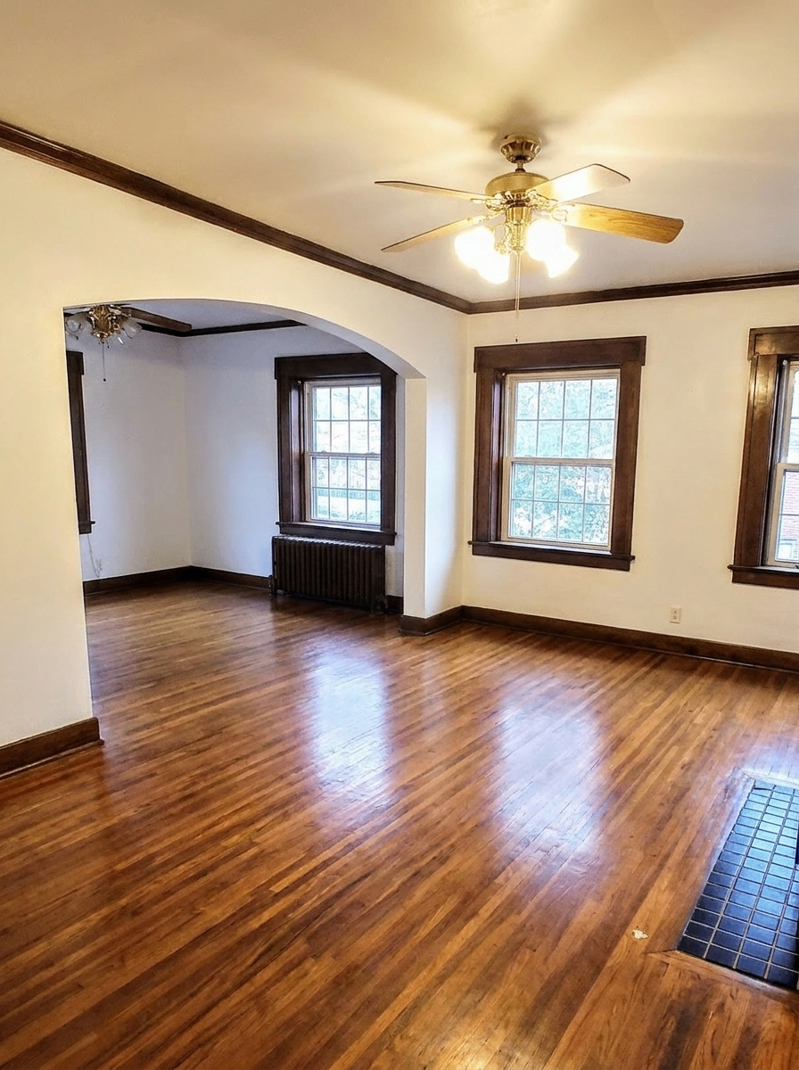 Unit C dining area with archway, ceiling fan, and hardwood floors
