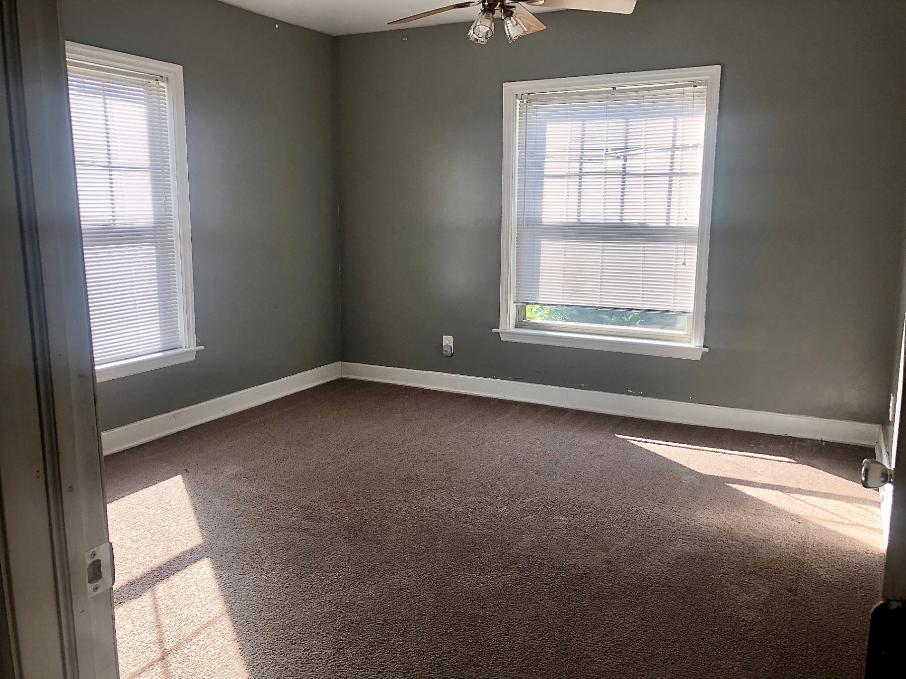 2034 Iuka Ave A bedroom with grey walls, ceiling fan, and bright windows